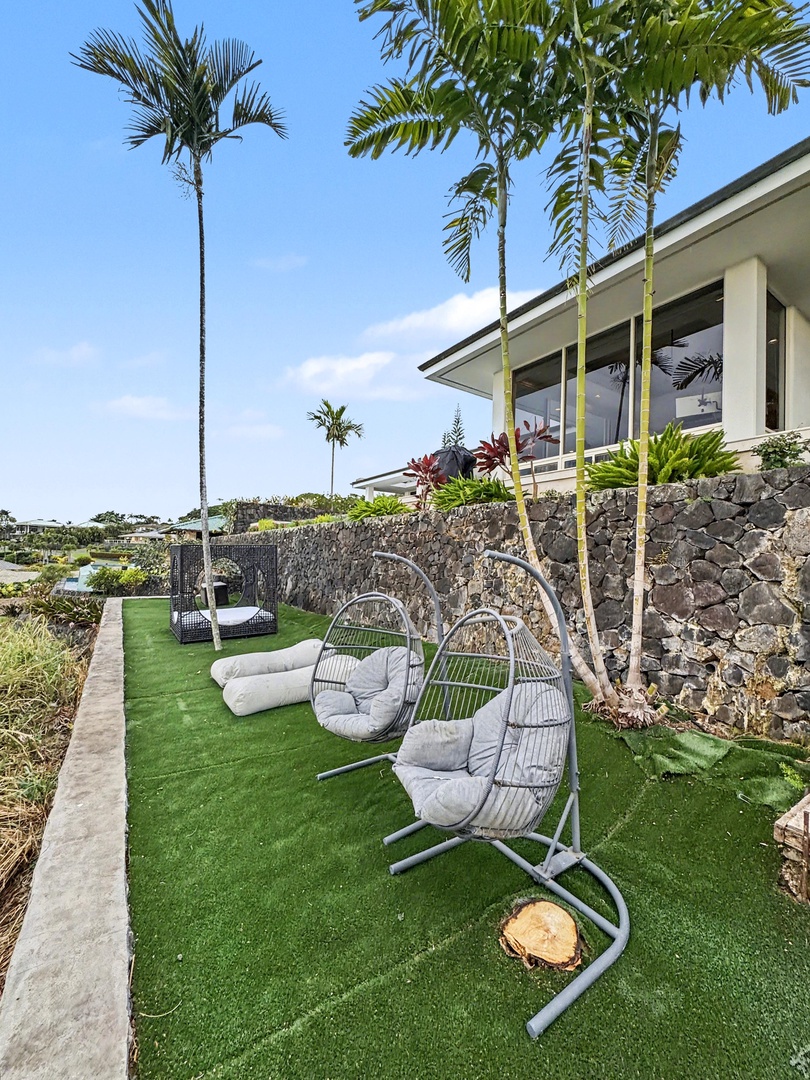 Kailua Kona Vacation Rentals, Hale Nai'a - Your private tropical lanai features cozy hanging chairs and plush seating where you can unwind beneath swaying palms.