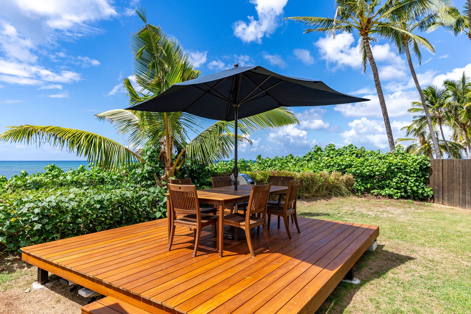 Waialua Vacation Rentals, Mokuleia Beach Villa** - Enjoy al-fresco dining experience with ocean views and tropical breezes on the expansive deck.