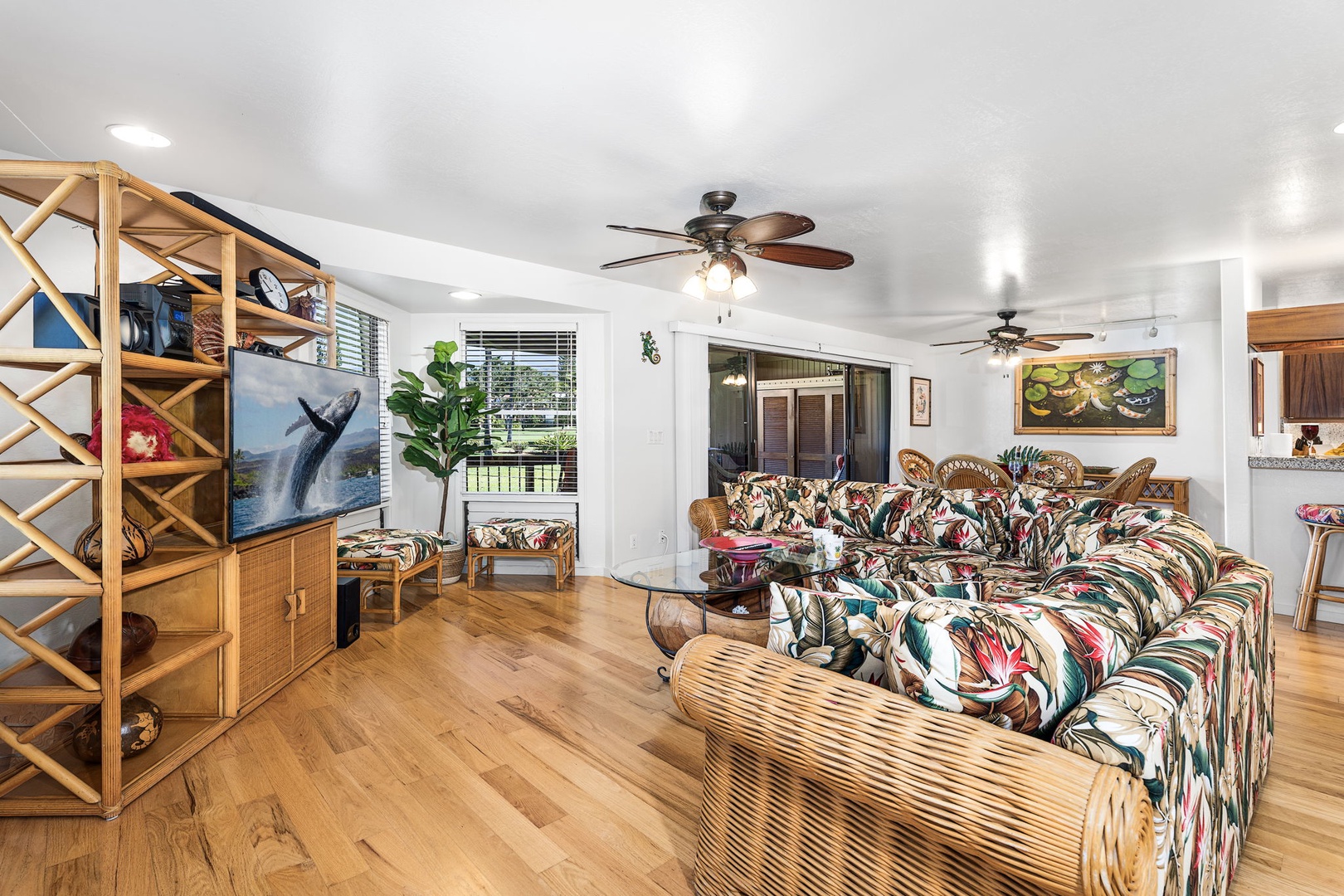 Kailua Kona Vacation Rentals, Kanaloa at Kona 701 - Lounge in your tropical-themed living space with colorful Hawaiian-print furnishings, bamboo accents, and ocean artwork creating an island paradise atmosphere.