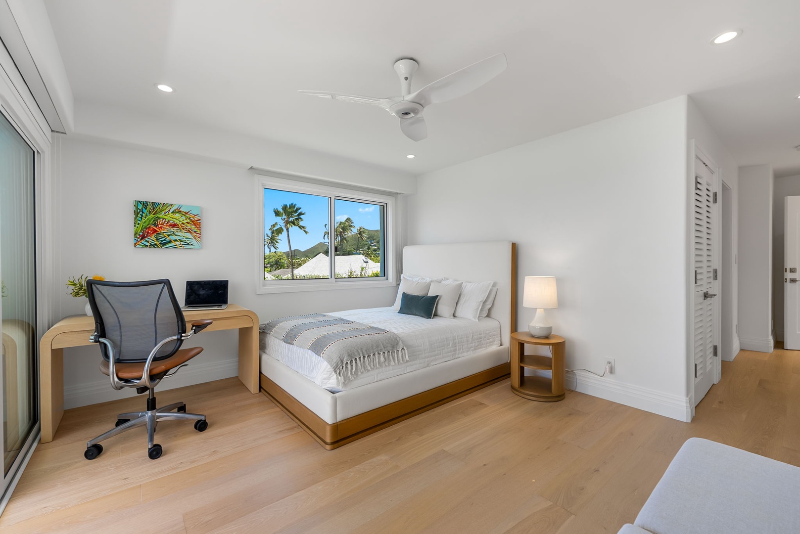 Kailua Vacation Rentals, Lanikai Sunrise Estate - Comfortable queen guest room with a writing desk, ceiling fan, and a breezy tropical outlook.
