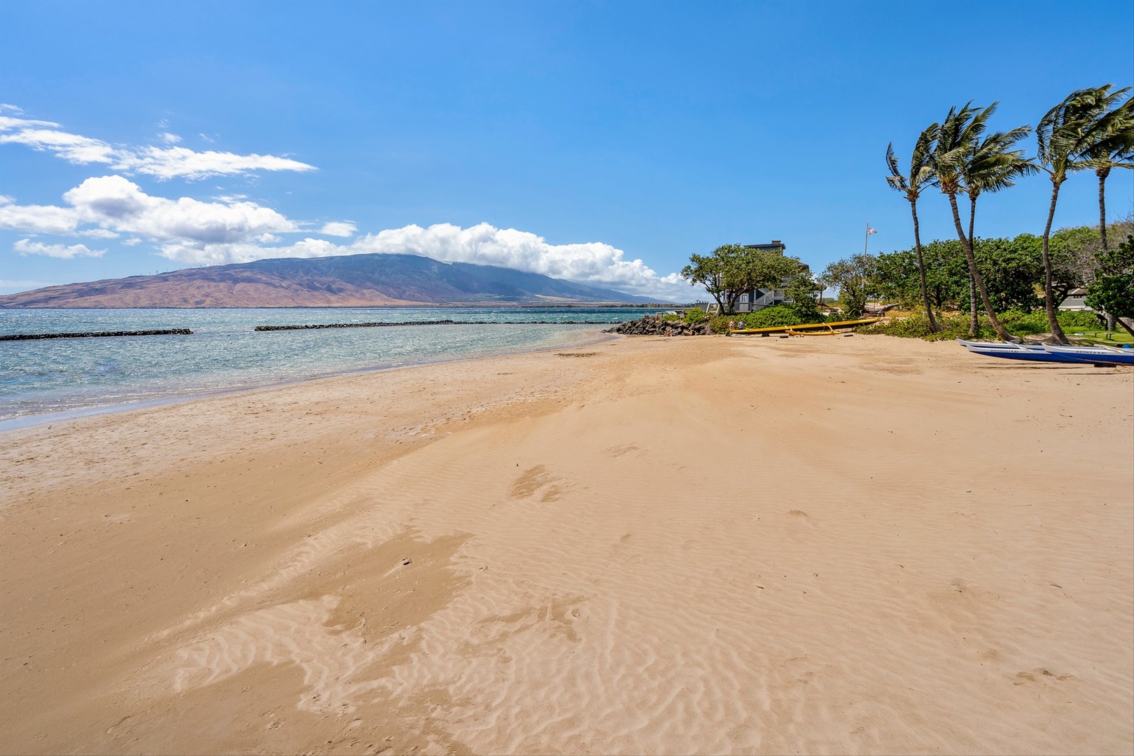 Kihei Vacation Rentals, Menehune Shores 420 - Walk out to a wide stretch of sand with the bay curving off toward the mountains.
