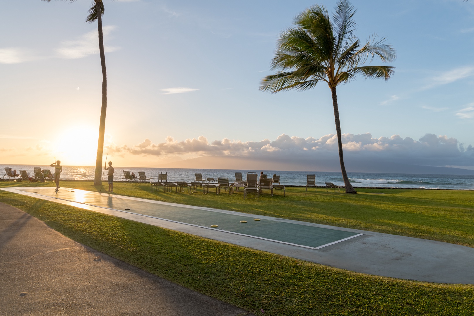 Lahaina Vacation Rentals, Papakea B-105 - The open grassy area and shuffleboard court provide the perfect setting for relaxation and recreation as the day winds down.