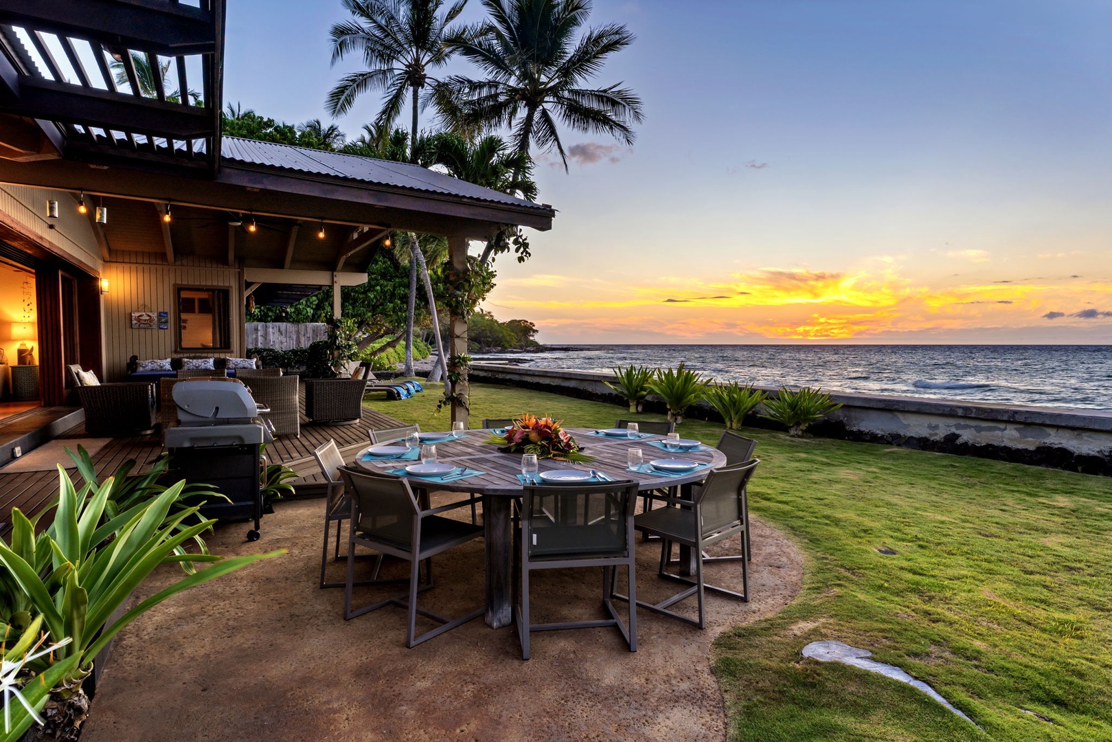 Kamuela Vacation Rentals, Island Time Retreat - The outdoor dining table right at the water, set for dinner as the sun drops.