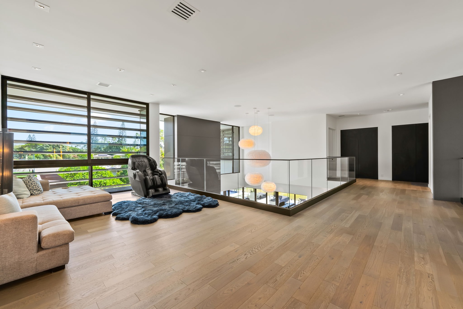 Honolulu Vacation Rentals, Ocean Villa 3 Bedroom - Spacious upper lounge with a futon, warm wood floors, and open flow.