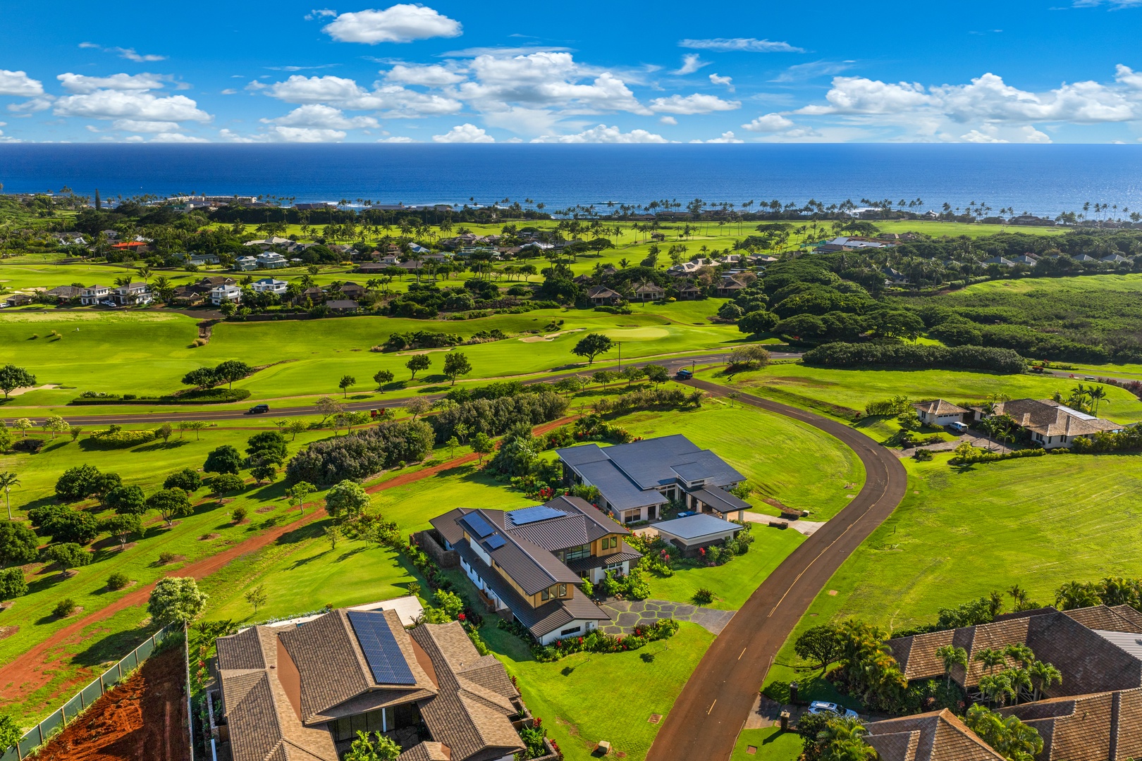 Koloa Vacation Rentals, Hale Laule'a at Kukui'ula - Aerial view showcases the property's prime location amid lush golf courses with stunning ocean backdrop and tropical landscape.