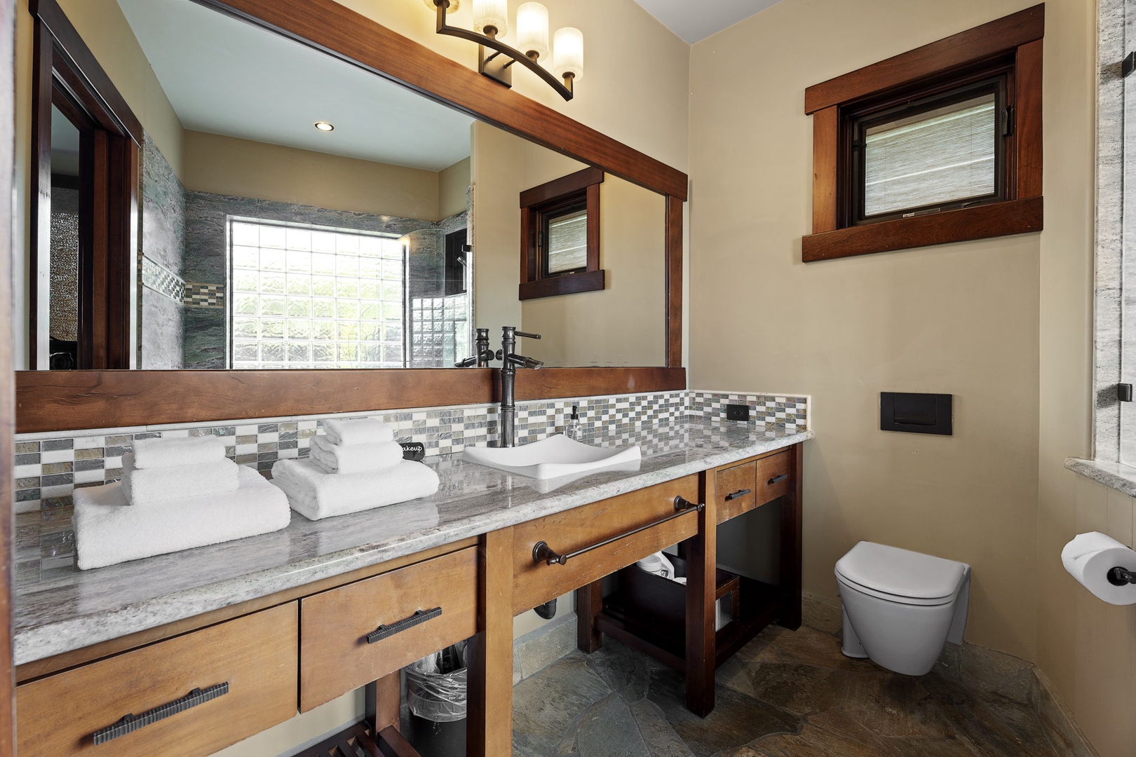 Kamuela Vacation Rentals, Hale Konane - Elegant ensuite bathroom with a double vanity and warm lighting for a spa-like feel.