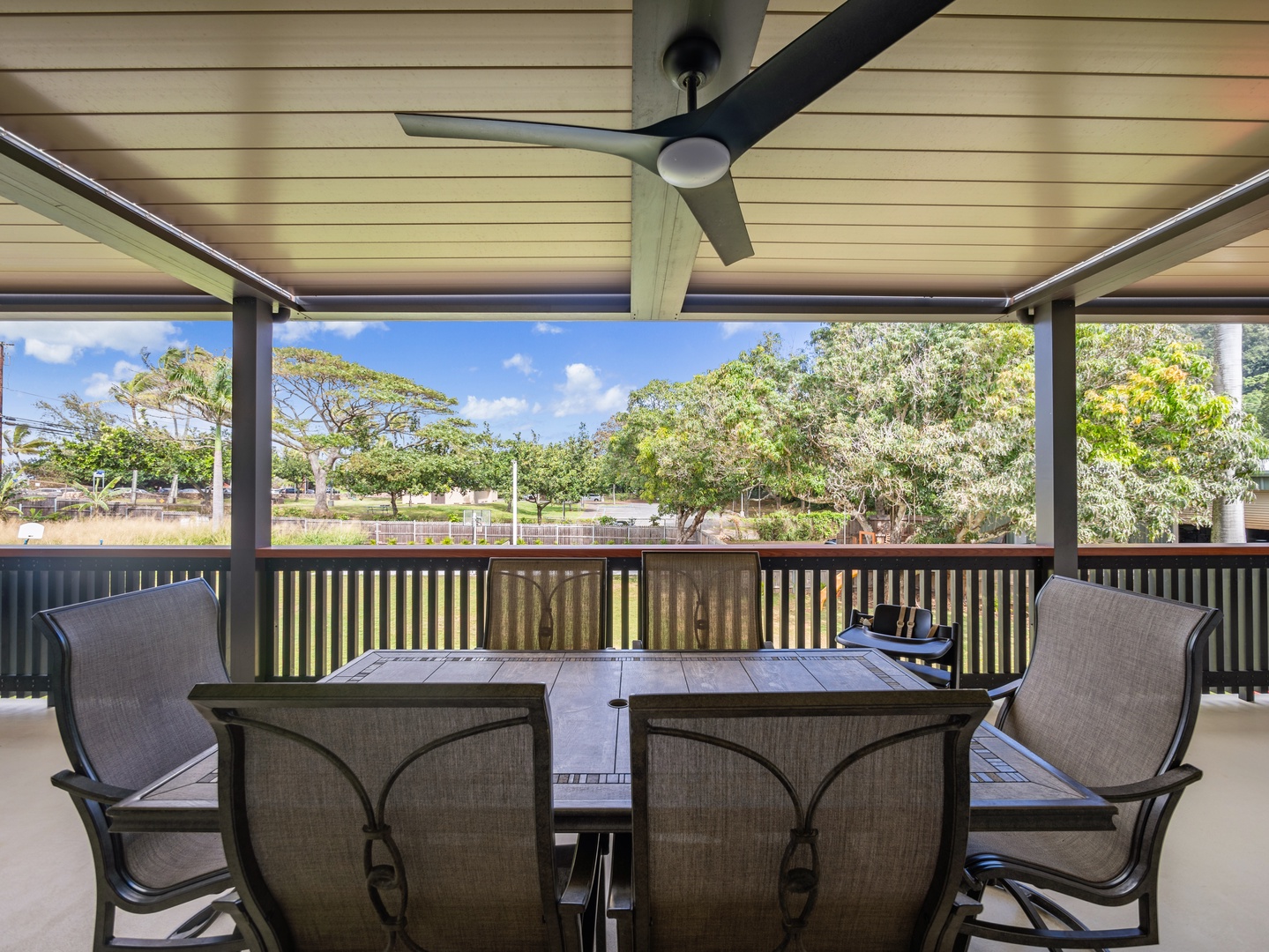 Haleiwa Vacation Rentals, Sunset Beach Island Retreat - Enjoy an outdoor meal or refreshing drink in the shaded comfort of this lanai, with peaceful views of lush greenery in the background.