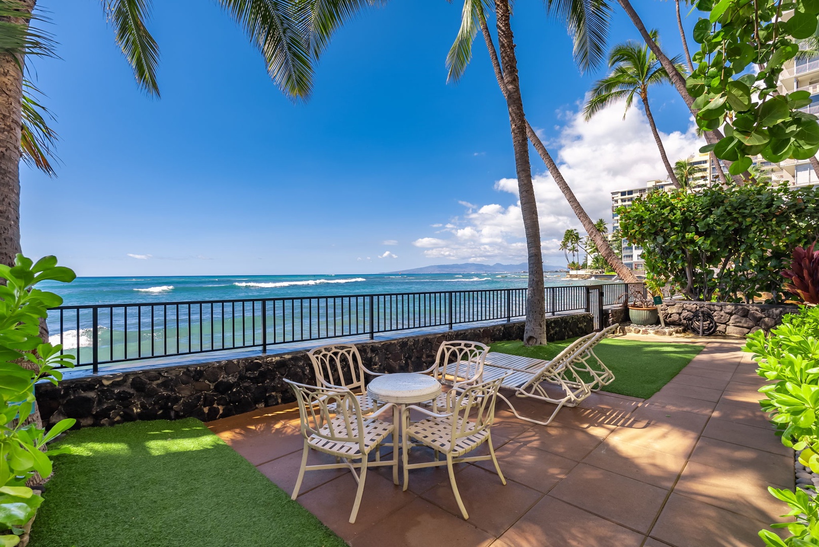 Honolulu Vacation Rentals, Kaimana Views - Outdoor seating area with ocean views, palm trees, and cool breezes—ideal for relaxation and enjoying the island’s beauty.