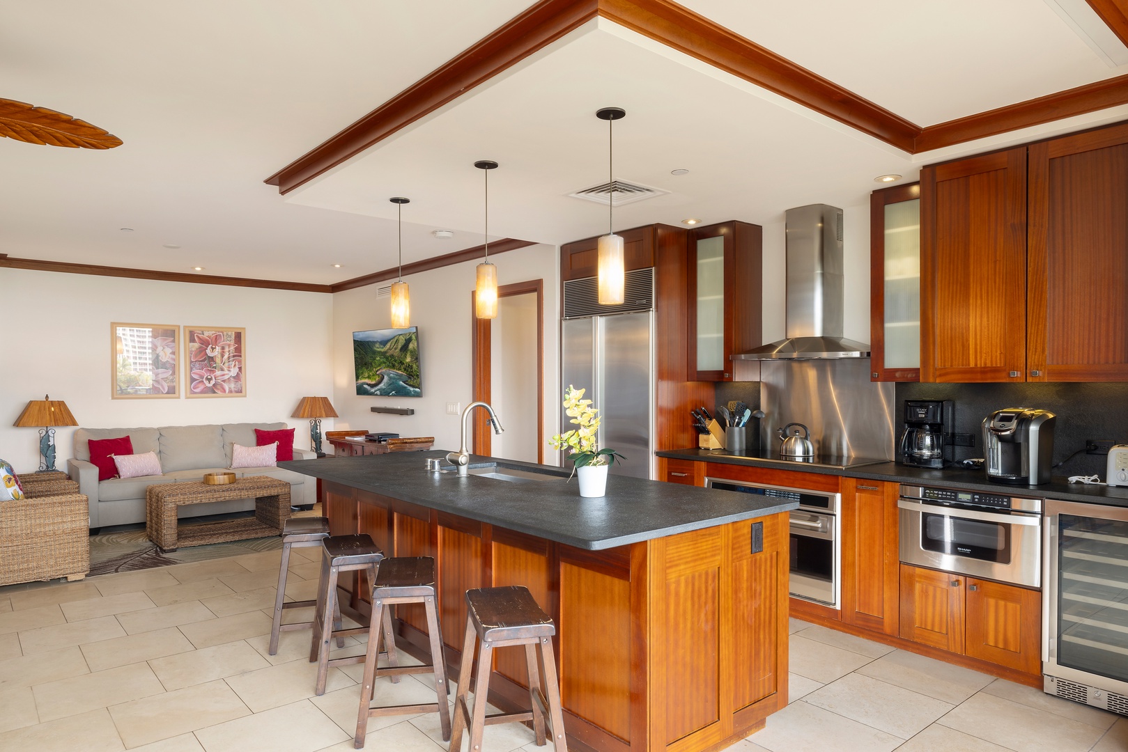 Kapolei Vacation Rentals, Ko Olina Beach Villas B506 - Your spacious kitchen flows seamlessly into the living area, featuring rich wood cabinetry, stainless steel appliances, and an island perfect for cooking together.