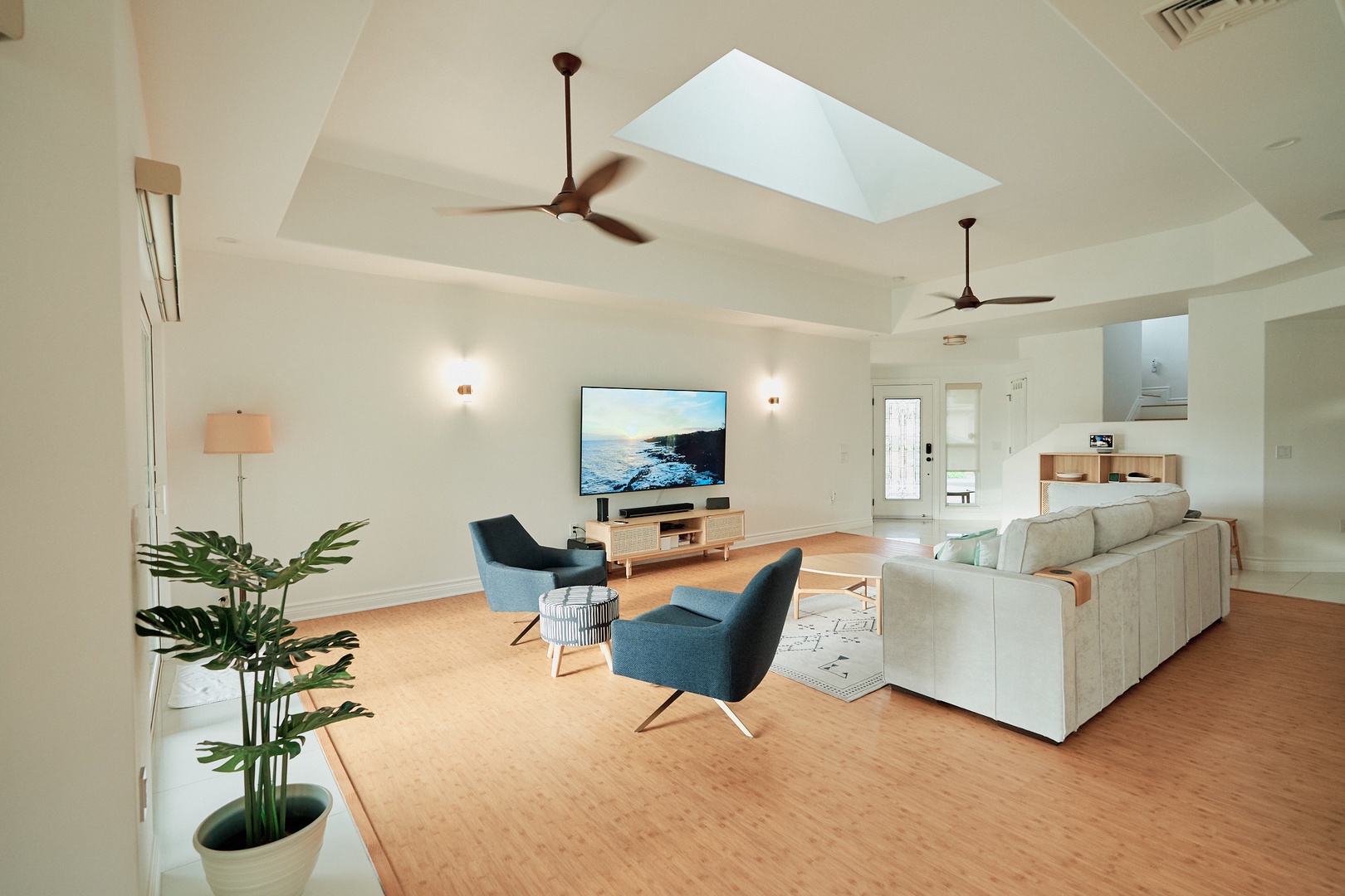 Princeville Vacation Rentals, Hale Kai - Relax in your spacious living room featuring a skylight, modern furniture, and open-concept design that flows seamlessly into the kitchen area.