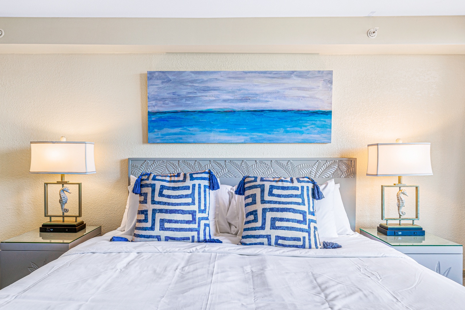 Lahaina Vacation Rentals, Kaanapali Shores 502 - This stylish bedroom invites relaxation with its serene ocean-themed artwork and plush pillows. The neutral tones create a calming atmosphere