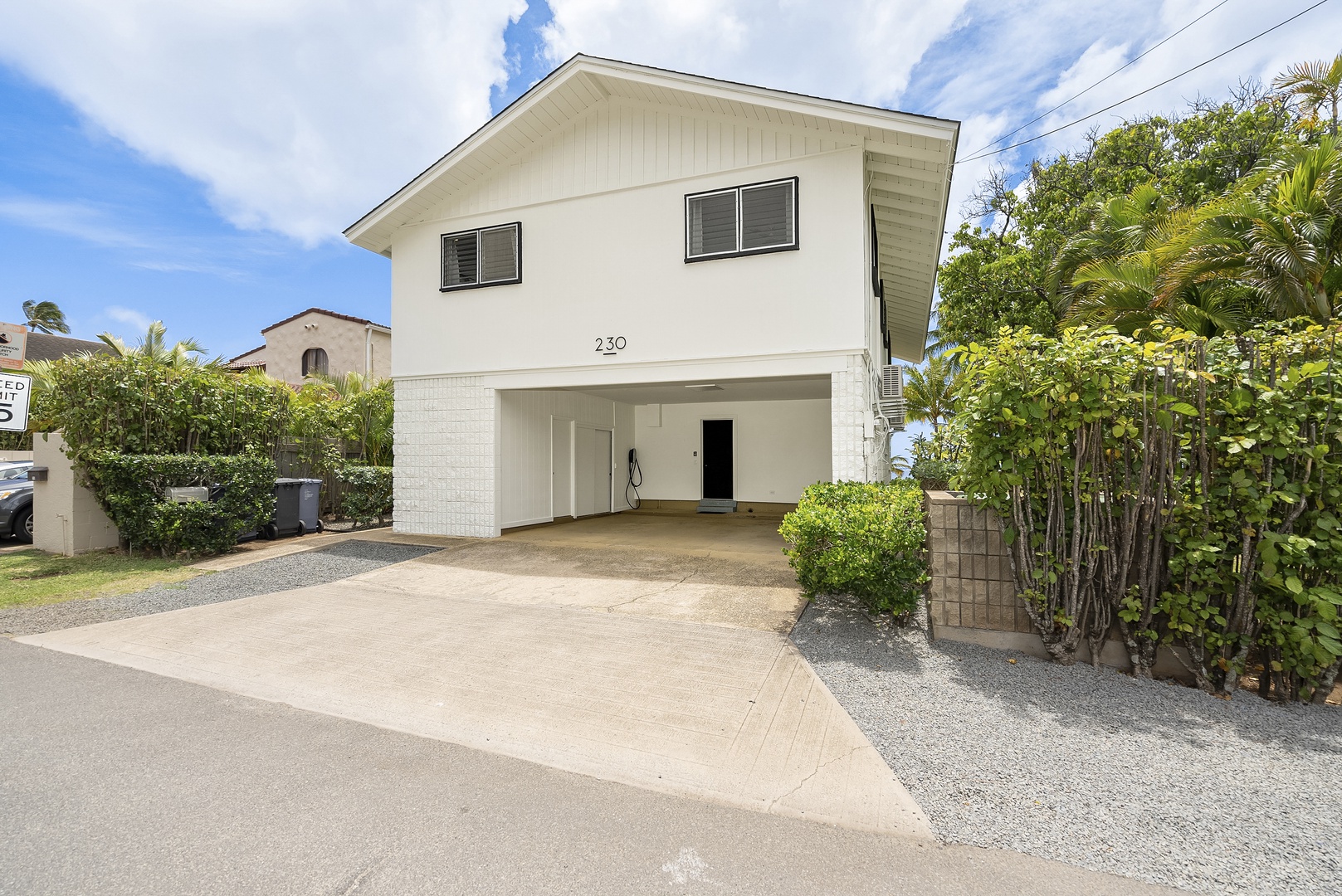 Honolulu Vacation Rentals, Honolulu Beachfront Retreat - Front view of the house with a large driveway and well-manicured greenery.