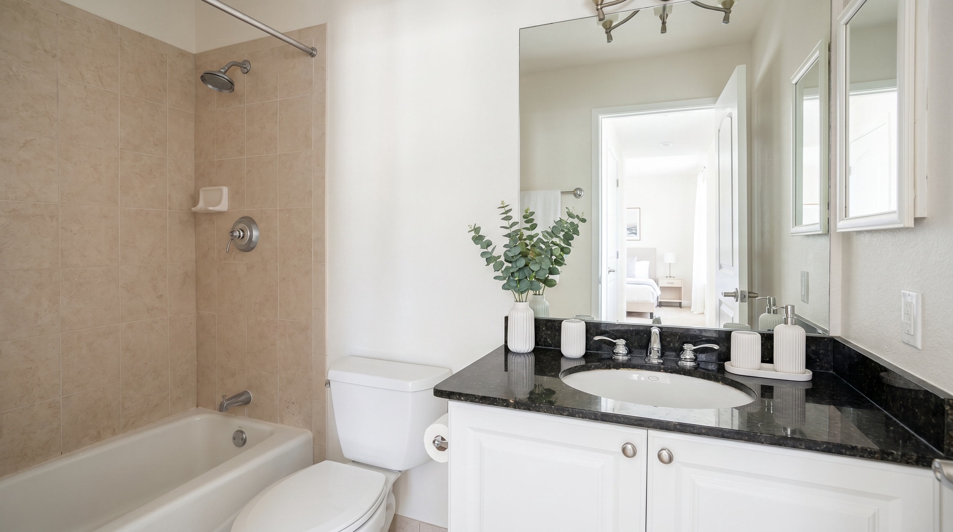 Rinse off the sunscreen in the tub-shower, with a black granite vanity close at hand.