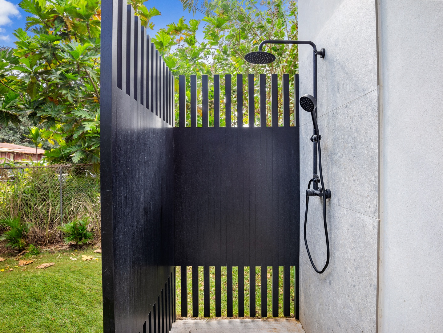 Haleiwa Vacation Rentals, Sunset Beach Island Retreat - This sleek outdoor shower provides a refreshing retreat after a day in the sun, offering a modern design with privacy and a connection to nature.