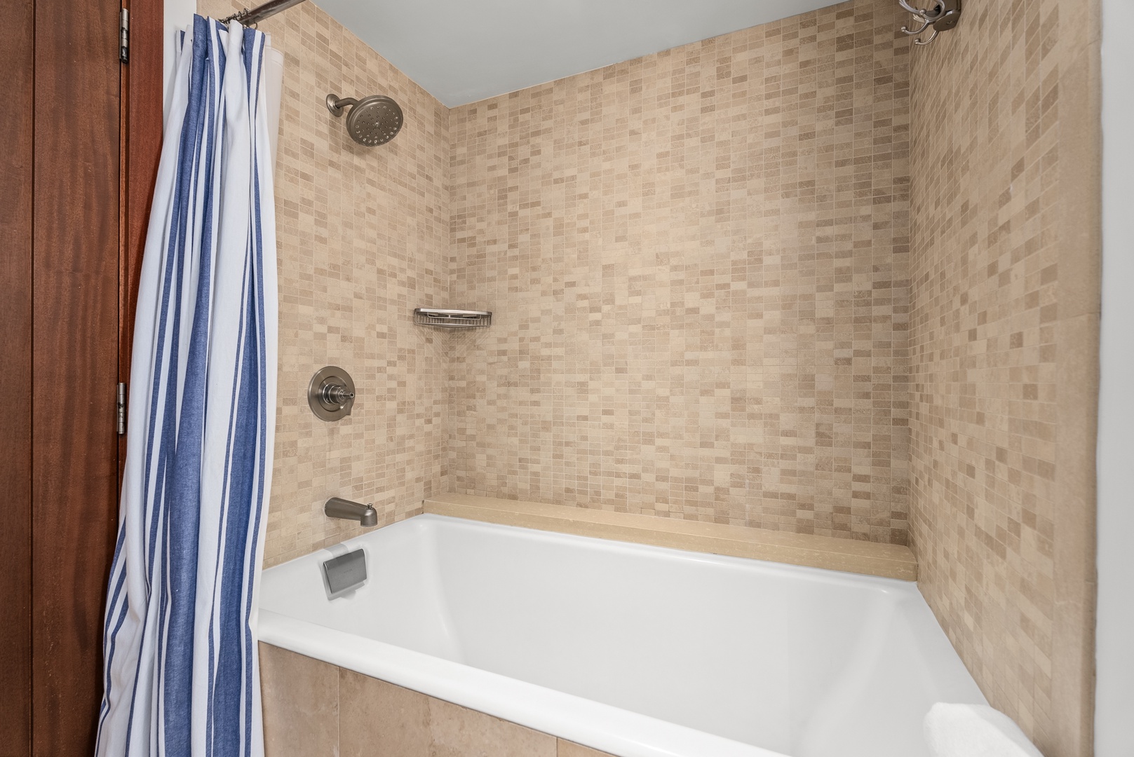 Mosaic tile and a tub-shower combination give the guest bathroom a clean, polished feel.
