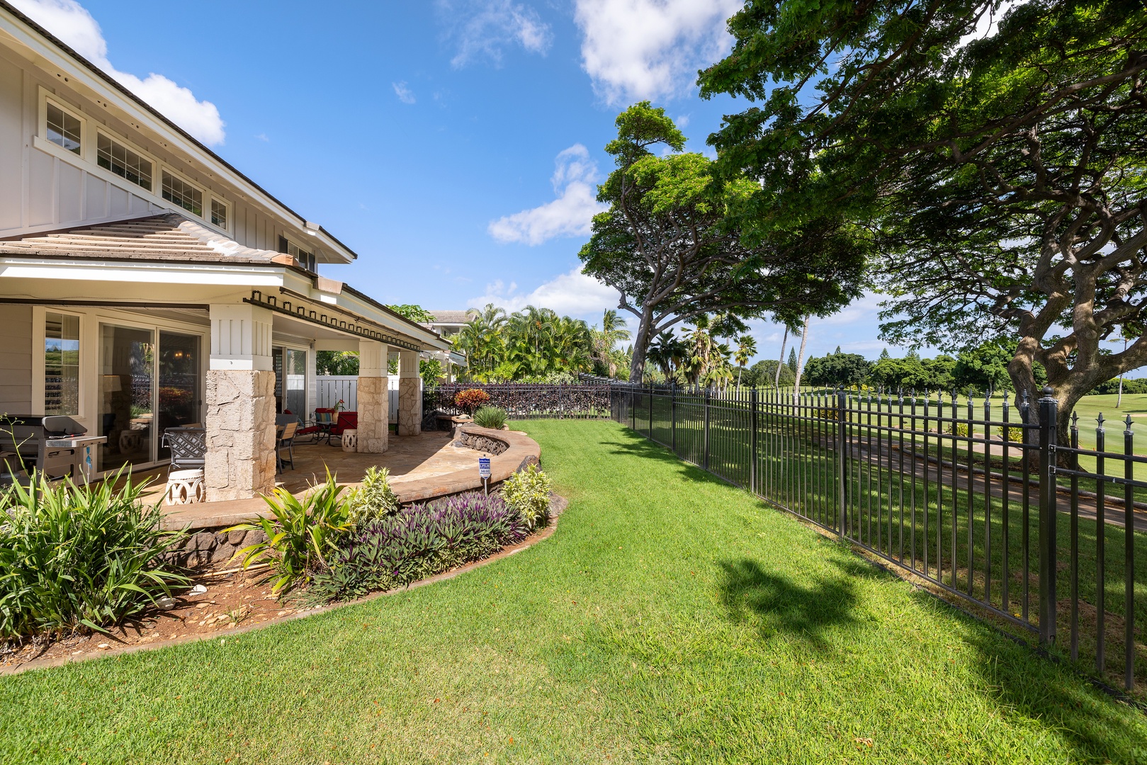 Expansive lawn and covered lanai create your perfect outdoor retreat, with lush gardens and mature trees providing natural shade.