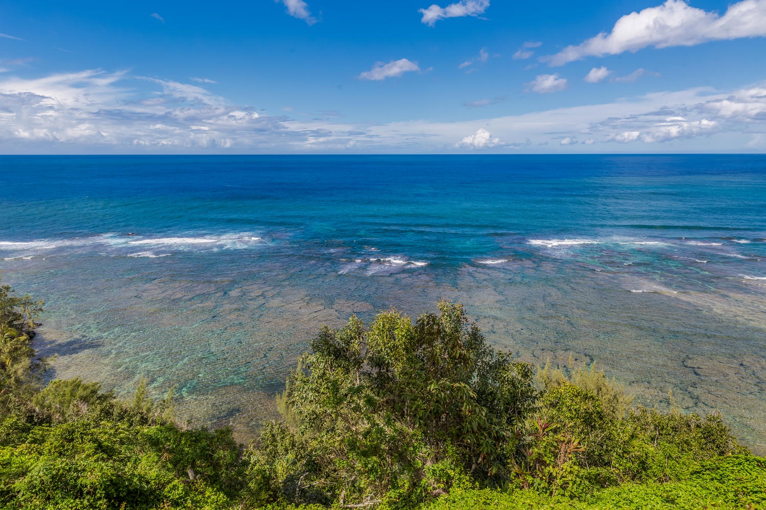 Princeville Vacation Rentals, Ola Hou - Entire Property - Sparkling waters and rugged coastline under a bright blue sky.