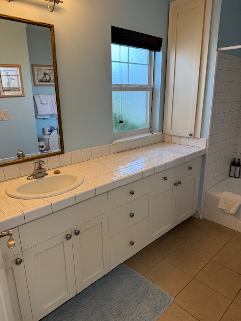 Princeville Vacation Rentals, Pili Aloha - Bright bathroom with a single sink, tub, and ample counter space.