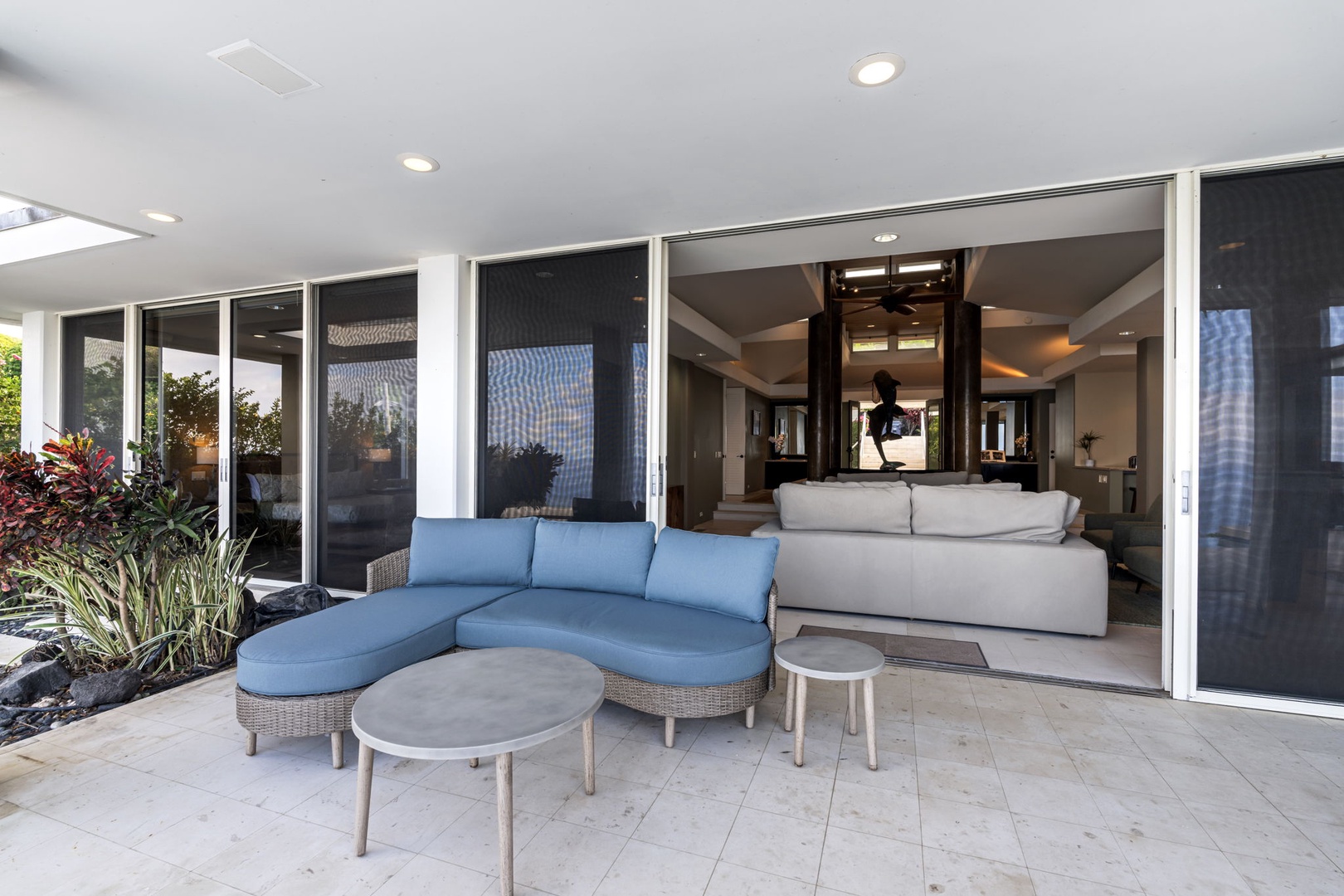 Kailua Kona Vacation Rentals, Hale Nai'a - Relax on your private patio with comfortable seating that flows seamlessly into your modern living space through floor-to-ceiling glass doors.