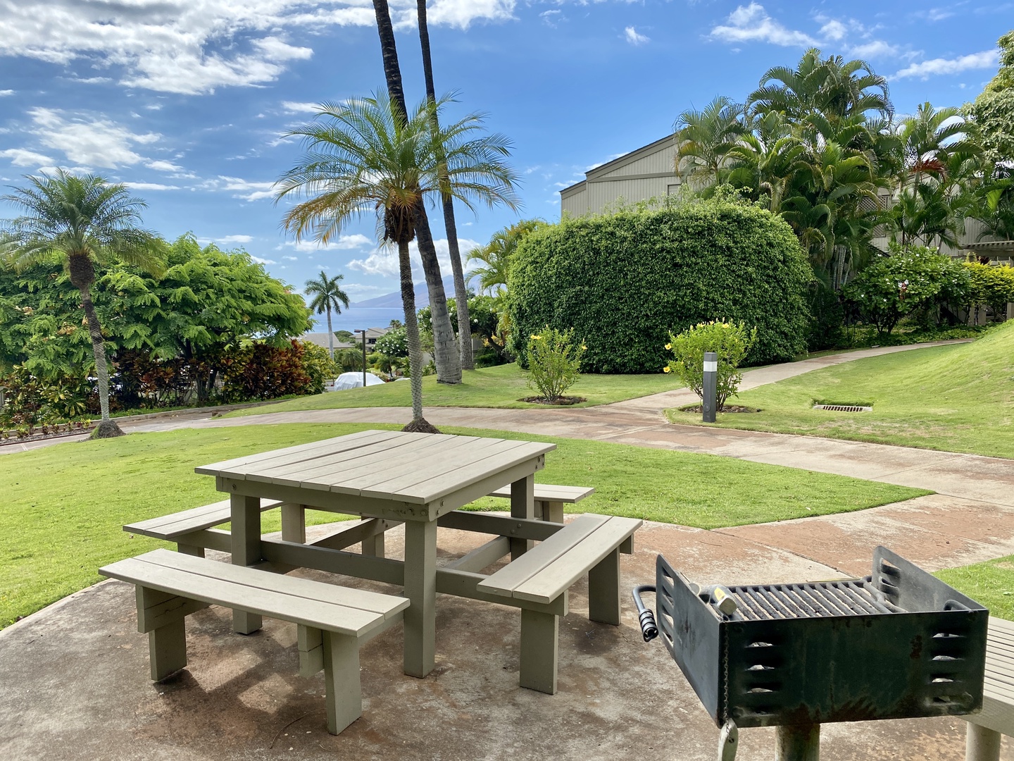 Kihei Vacation Rentals, Wailea Ekolu 1605 - A peaceful outdoor picnic and BBQ area, perfect for enjoying meals in the fresh air surrounded by lush greenery.