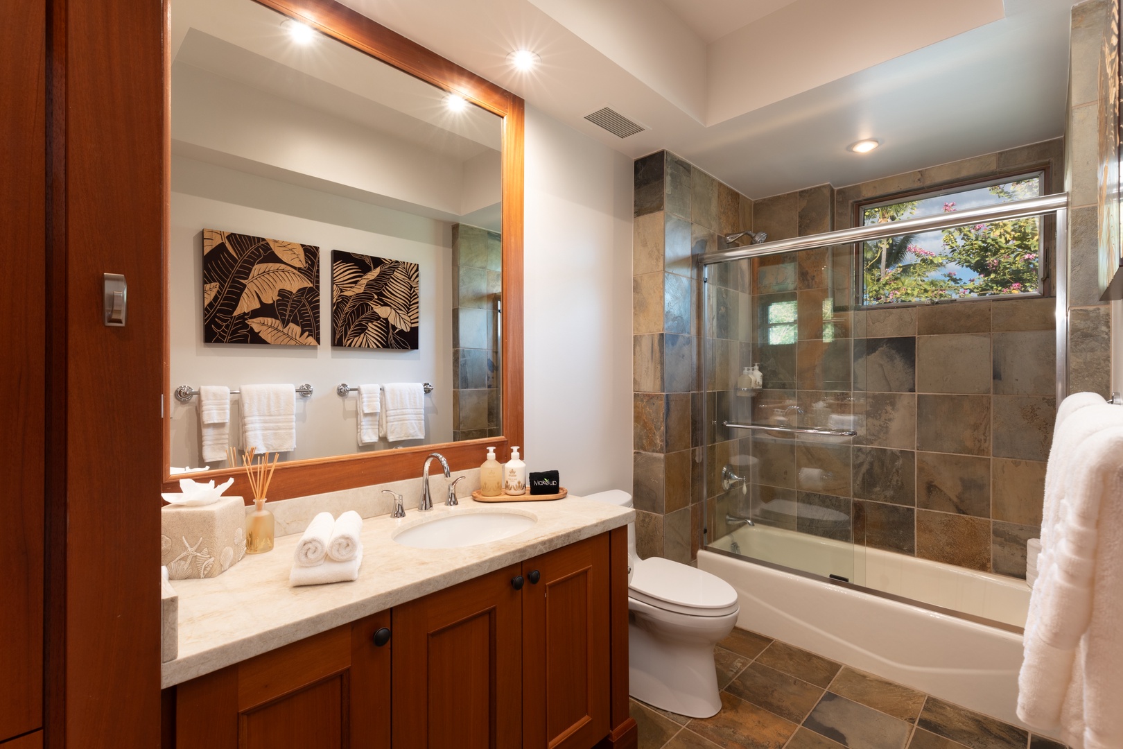 Kailua Kona Vacation Rentals, 3BD Waiulu Villa 111D at Hualalai Resort - Spacious bathroom with a shower tub featuring natural stone tiles and a sleek vanity.