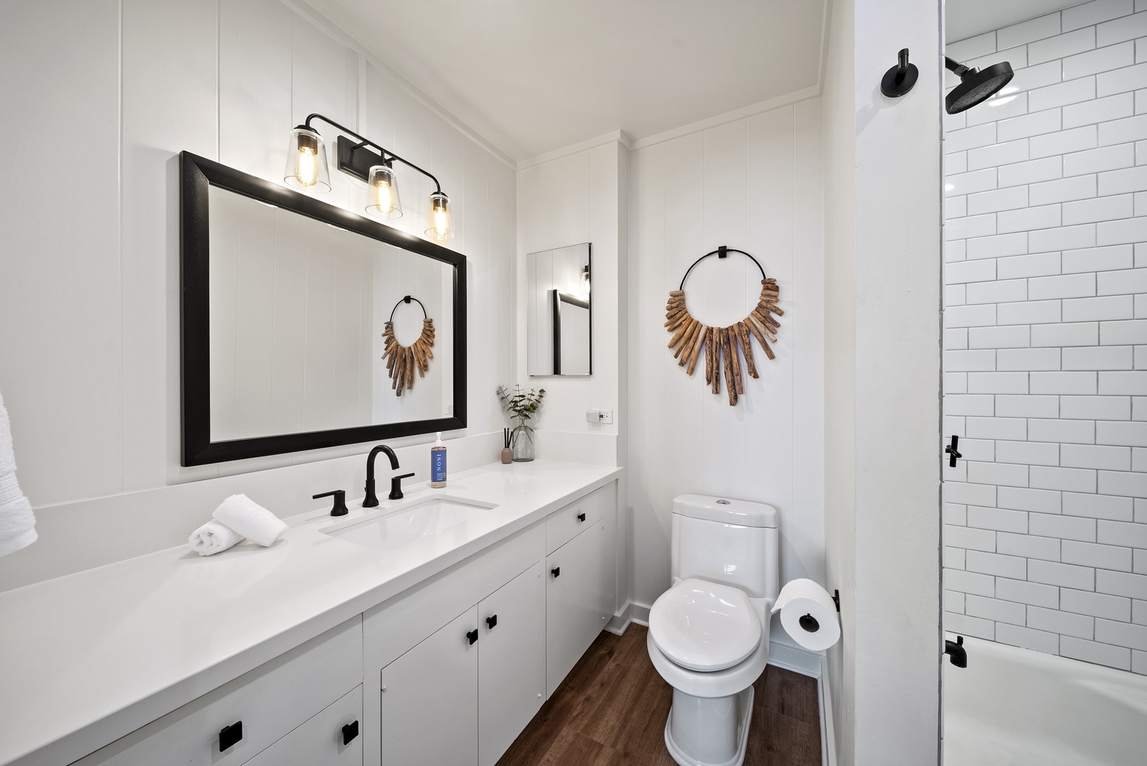 Honolulu Vacation Rentals, Honolulu Beachfront Retreat - Guest bathroom with a sleek double vanity, large mirror, and coastal-inspired décor — perfect for easy mornings.