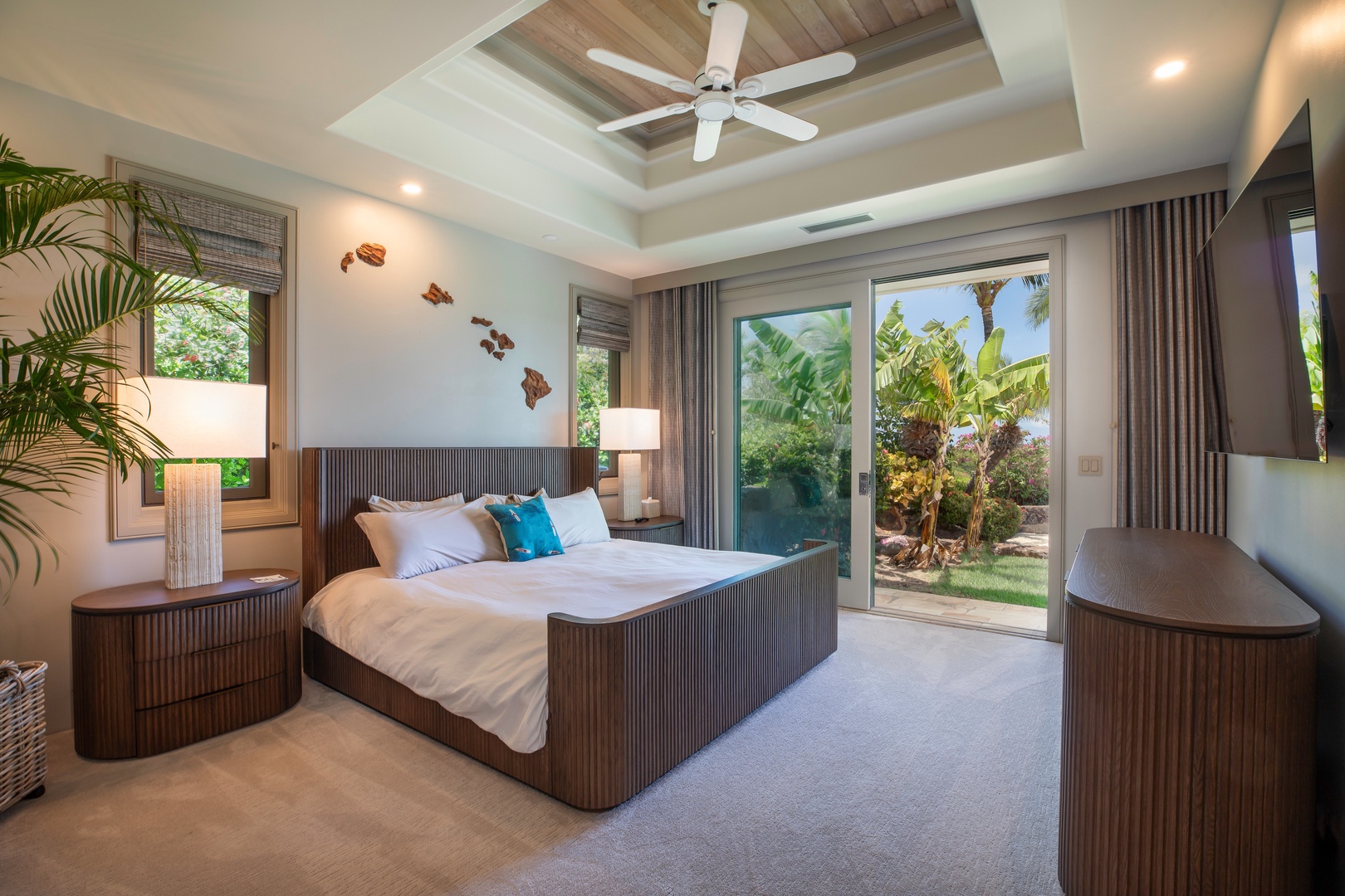 Kamuela Vacation Rentals, Canoe House at Champion Ridge - Bright bedroom with a stylish king-sized bed, ceiling fan, and floor-to-ceiling windows.
