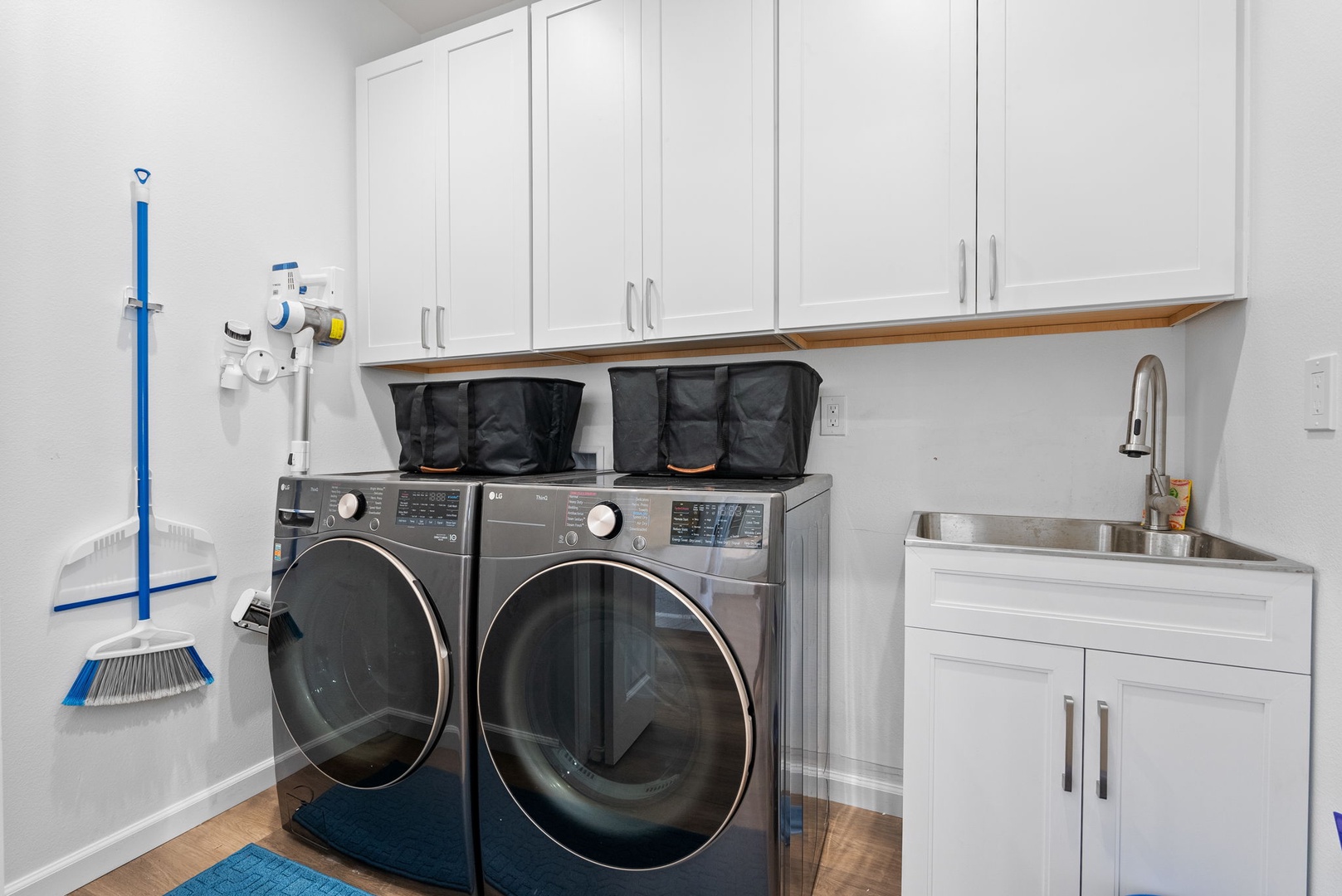 Waianae Vacation Rentals, Oceanfront Luxury Dream Estate - Main floor laundry room with top-loading machines, folding counter, and upper cabinets for convenience.