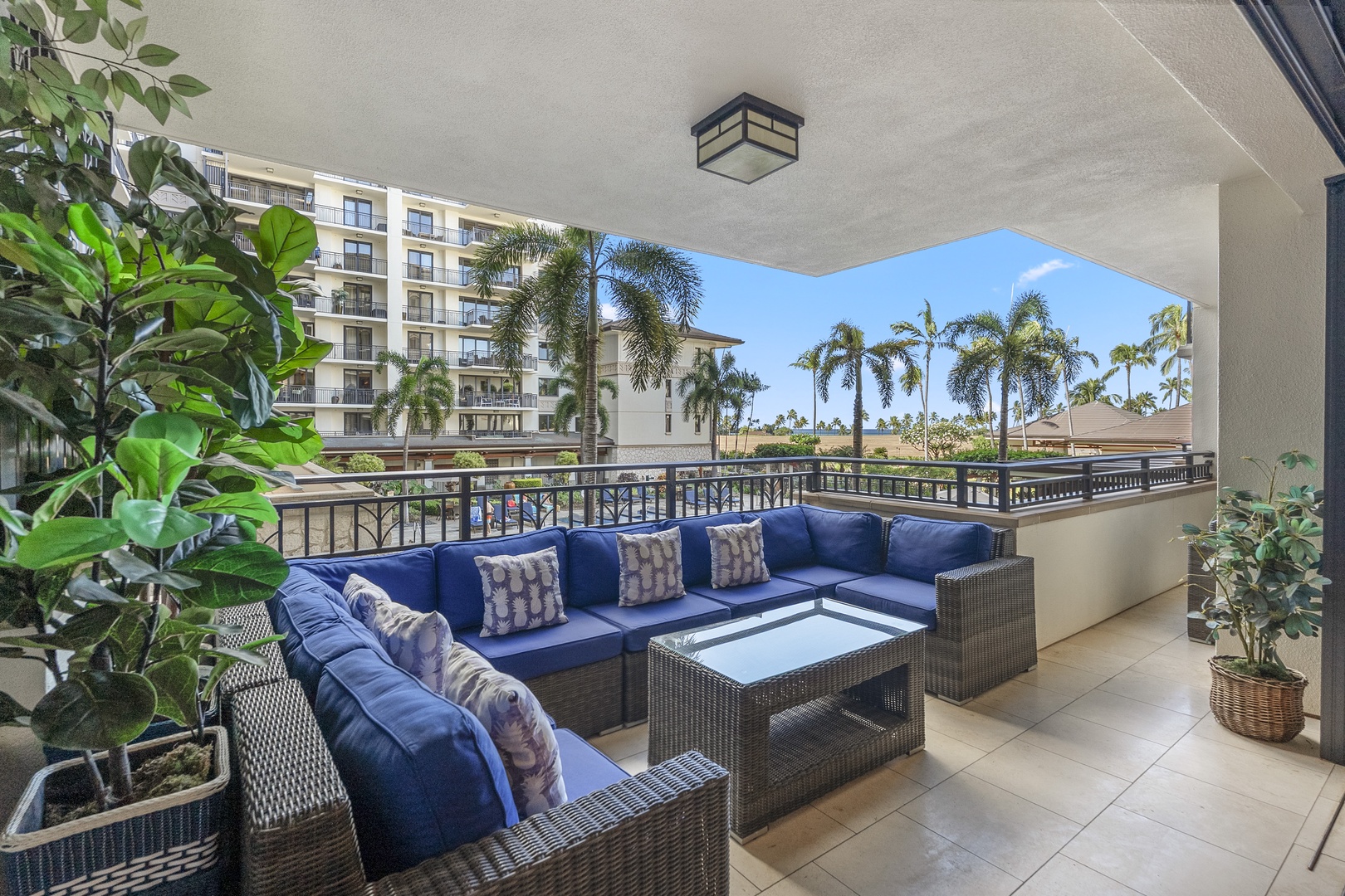 Deep seating and potted greenery make the lanai the best place to cool down in the afternoon.