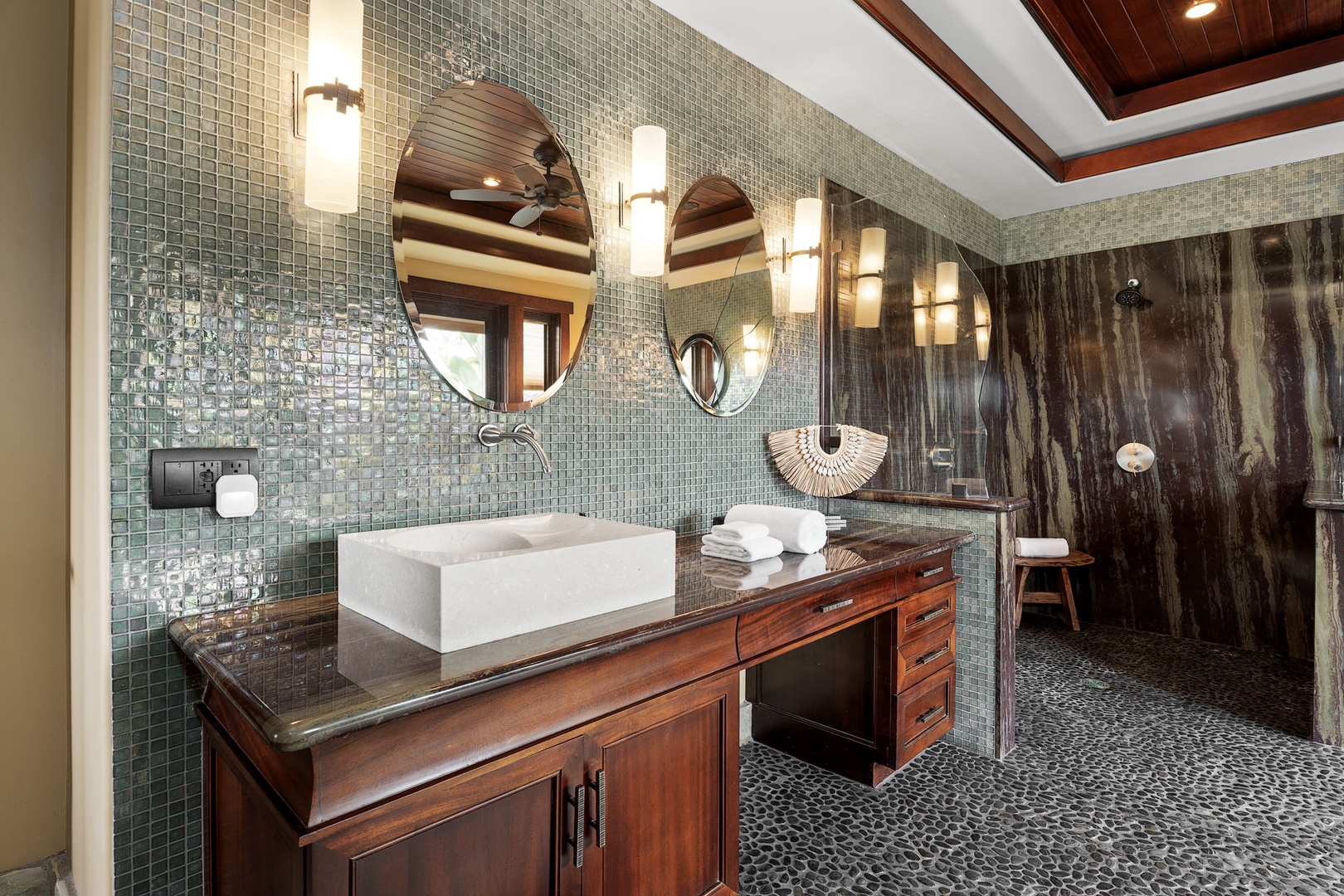 Kamuela Vacation Rentals, Hale Konane - Luxurious spa-inspired bathroom with dual vanities, warm lighting, and a sleek, walk-in shower.
