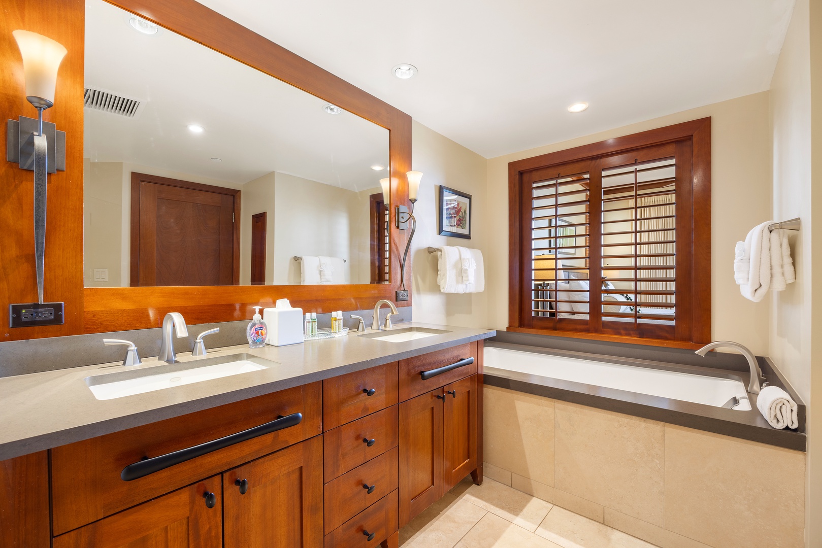 Kapolei Vacation Rentals, Ko Olina Beach Villas B609 - Unwind in your luxurious bathroom with rich wood cabinetry, dual vanities, and a deep soaking tub for ultimate relaxation.