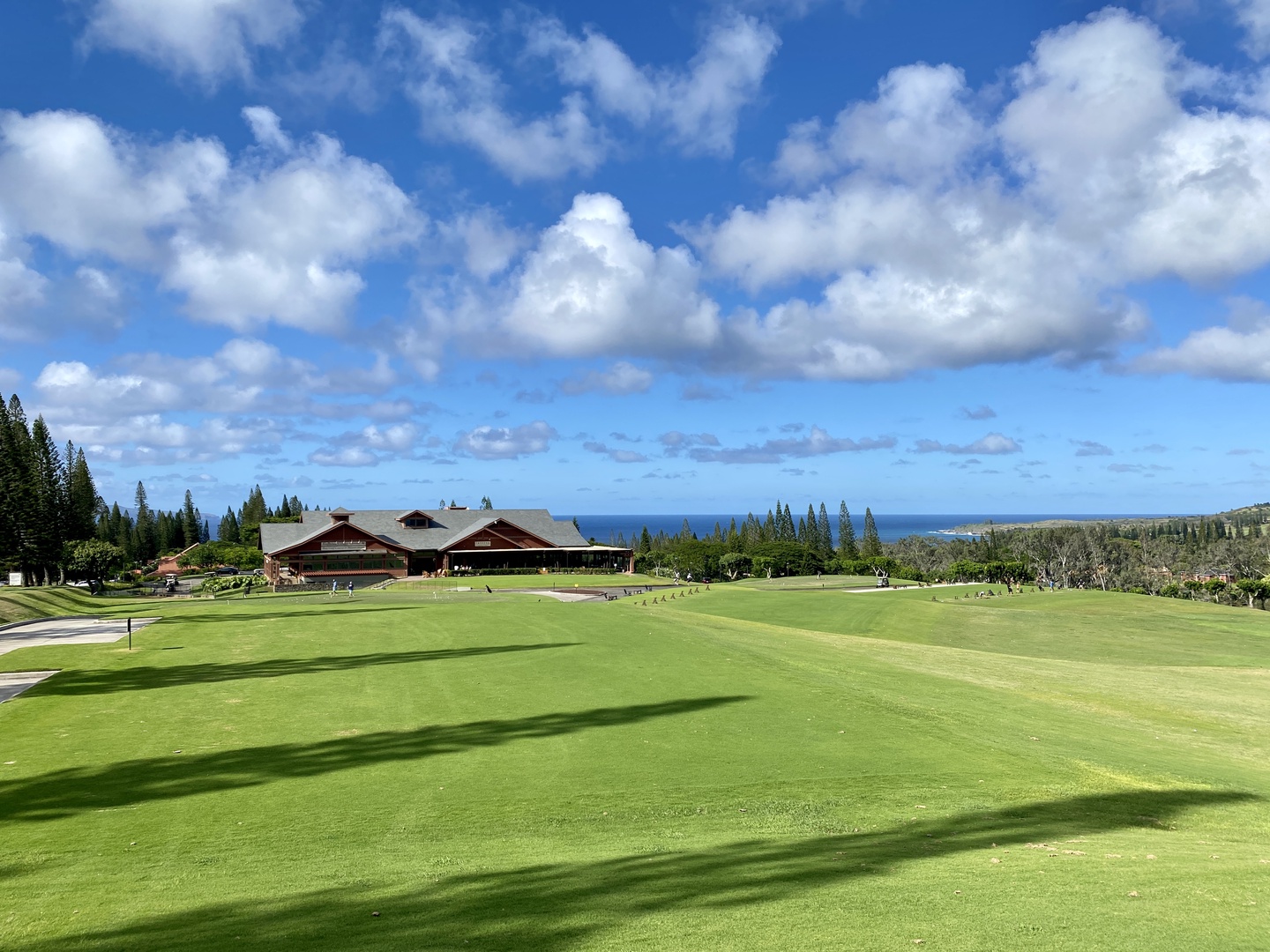 Lahaina Vacation Rentals, Kapalua Ridge 1421 - A lush green golf course set against the backdrop of a serene blue sky with scattered clouds.