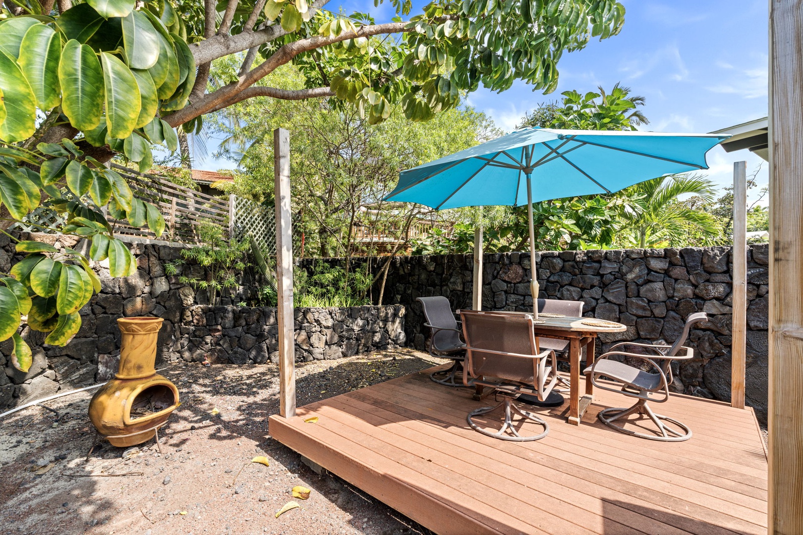 Kailua Kona Vacation Rentals, Mai Tai Manor - Relax on your private deck with shaded dining under tropical palms, complete with a charming clay chiminea for cozy evenings.