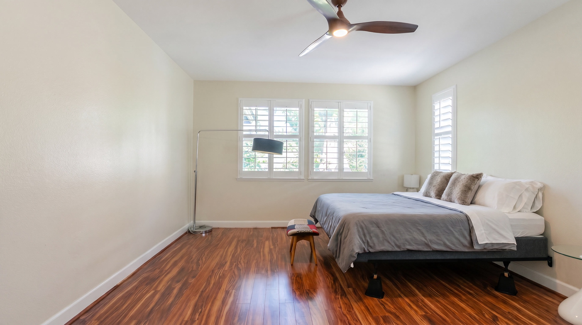 Primary suite with hardwood floors underfoot and plantation shutters to dial in the morning light.