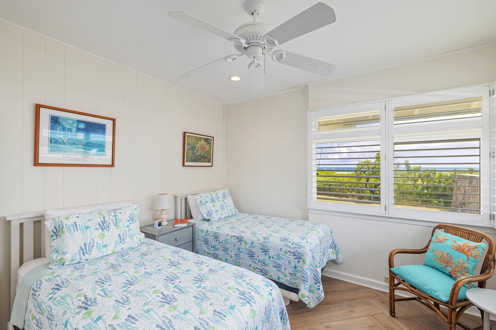 Kailua Vacation Rentals, Hale Moana Lanikai - This bright and airy bedroom is furnished with two comfortable twin beds, each dressed in vibrant, floral linens that echo the lush surroundings visible through the window