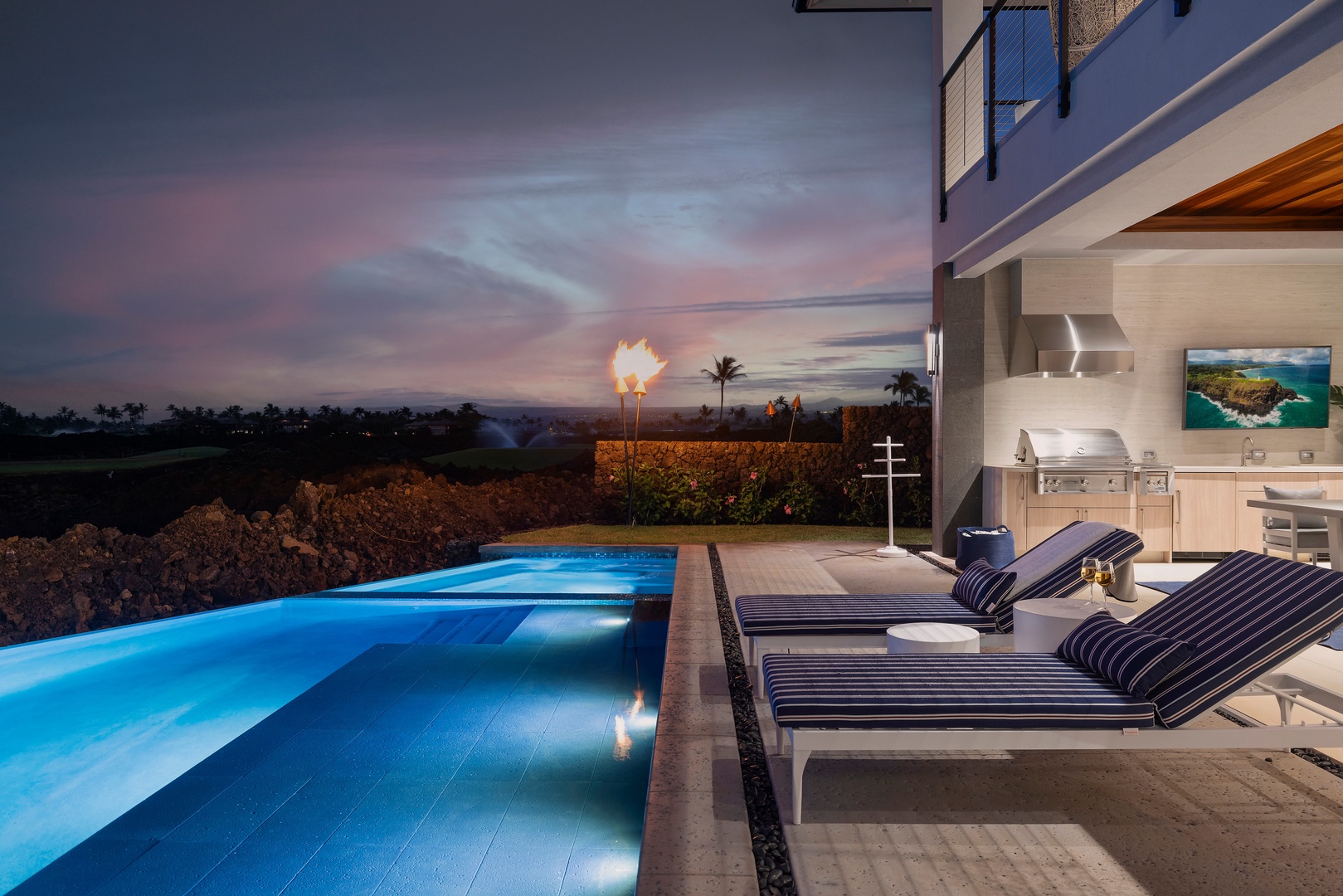 Kamuela Vacation Rentals, 6BD Mauna Lani Lux Golf Estate (6) at One Ocean - Lounge chairs face the glowing pool, with the covered lanai lit behind you.