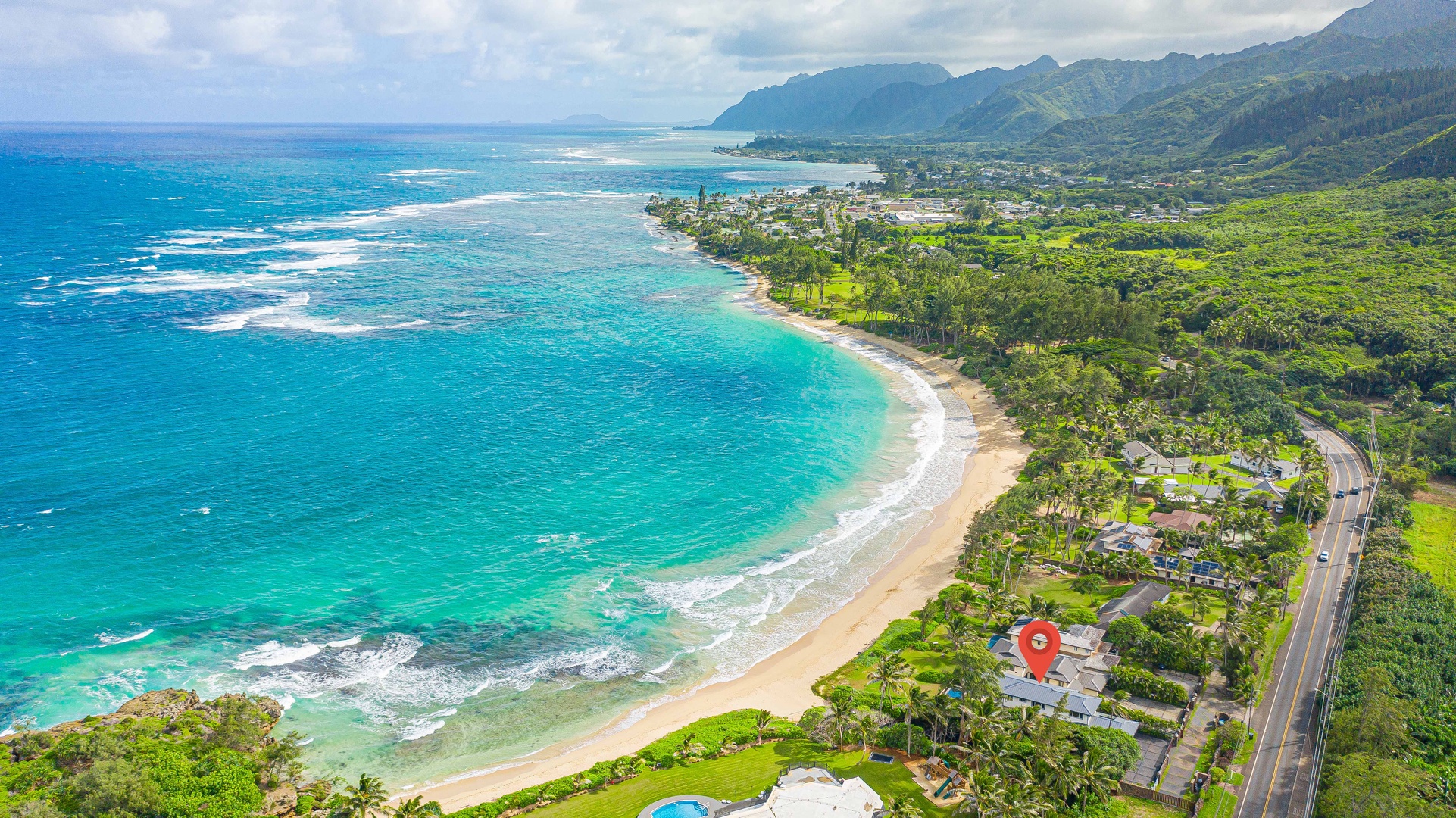 Laie Vacation Rentals, Majestic Mahakea Oceanfront Oasis - Breathtaking aerial view of the turquoise coastline, surrounded by lush greenery and mountains.