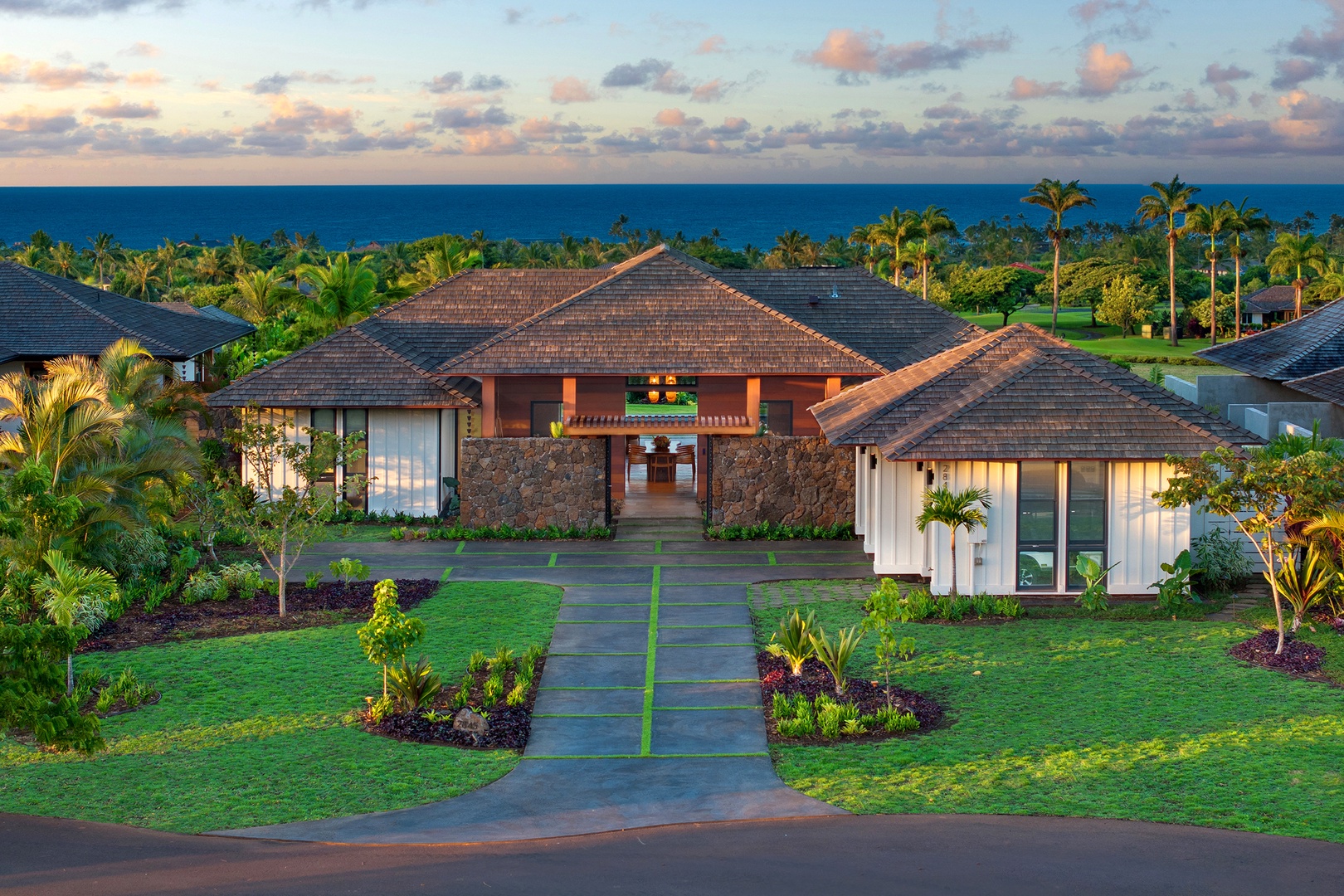 Koloa Vacation Rentals, Hale Ka Pua Ola at Kukuiula - Aerial view showcasing the stunning entrance and lush landscaping of the property.