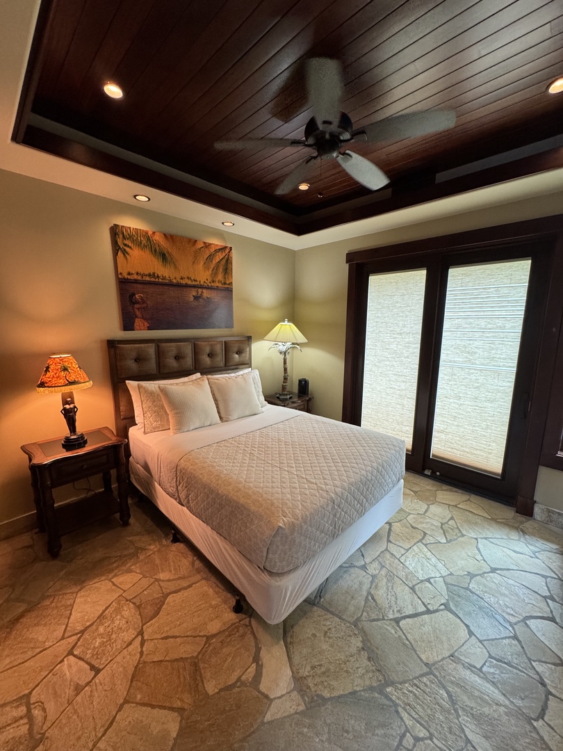 Kamuela Vacation Rentals, Hale Konane - Elegant suite featuring a plush queen-sized bed, warm lighting, and tropical decor.