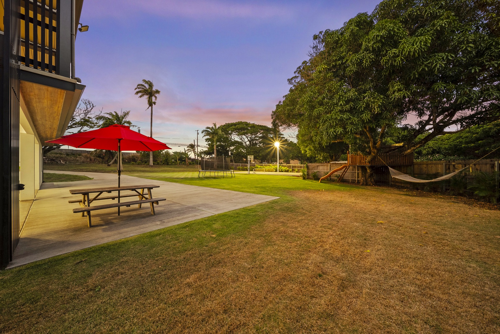 Haleiwa Vacation Rentals, Sunset Pickleball Paradise - Picnic area with shaded tables offers a serene spot for outdoor meals and gatherings under the sunset sky.