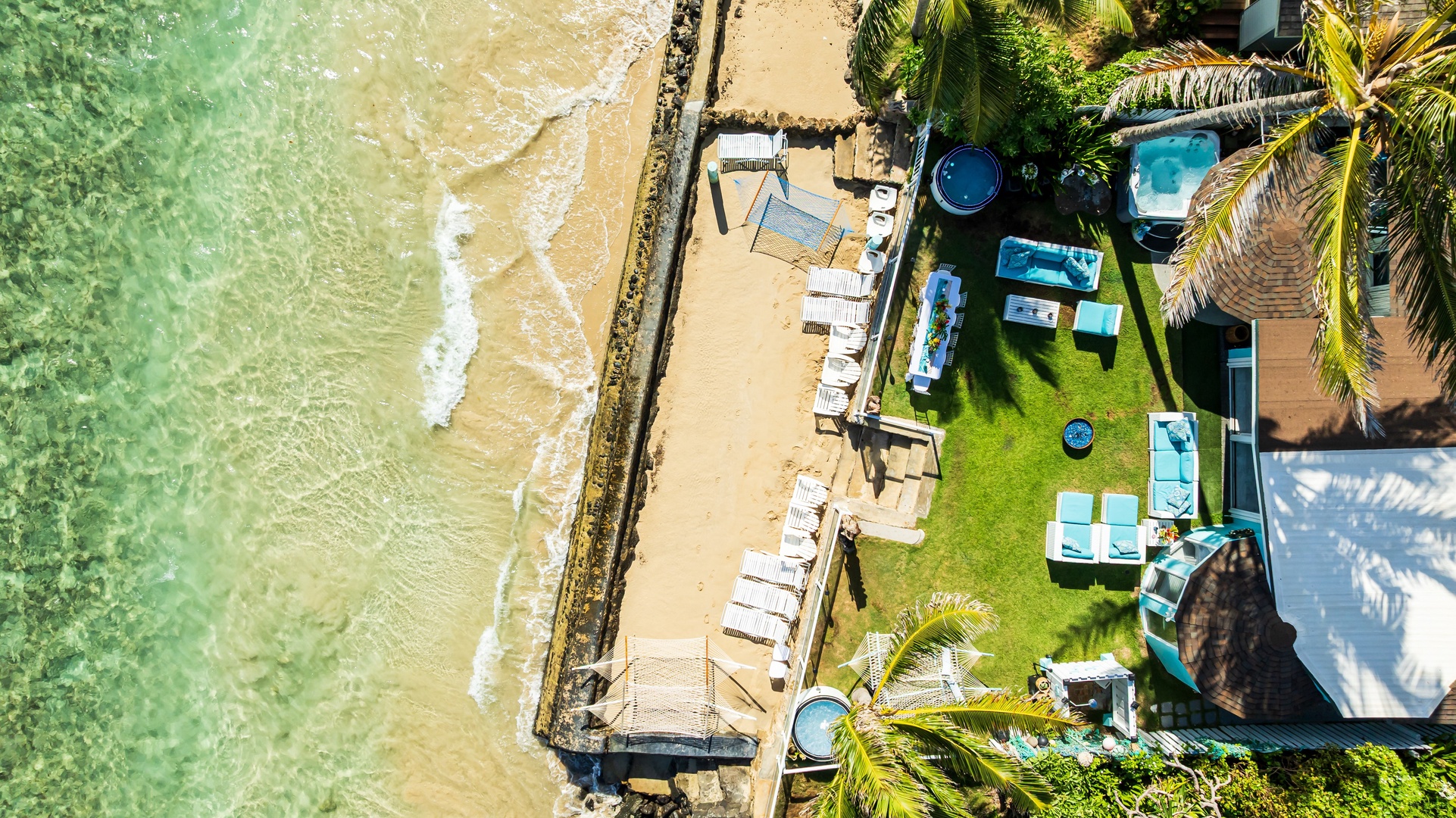 Hauula Vacation Rentals, Private Beach Paradise - Aerial view of a private beachfront estate with sandy shoreline and multiple outdoor lounging areas.