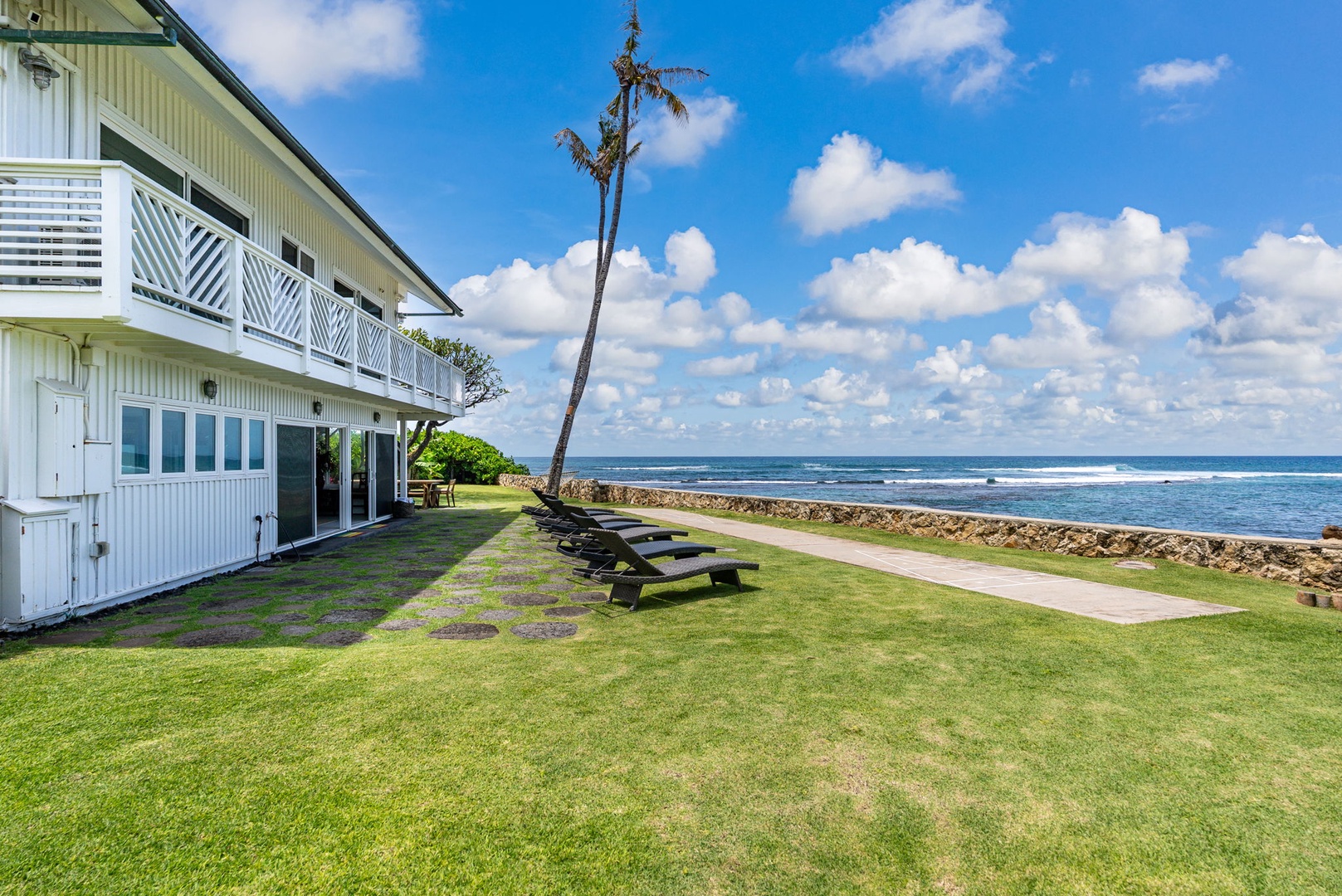 Waianae Vacation Rentals, Ma'ili Blue Estate - This stunning oceanfront property with private lawn area featuring picnic tables and swaying palm tree along the shoreline.