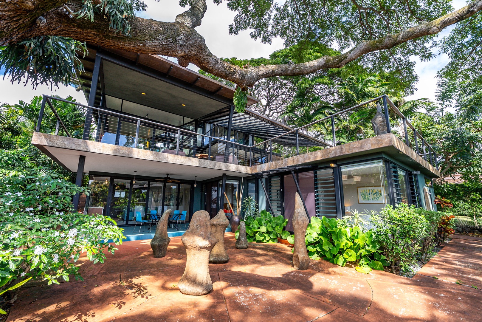 Honolulu Vacation Rentals, Tantalus Glass House (3 BD) - A striking modern villa nestled among lush tropical trees, featuring contemporary architecture with glass walls and private balconies.