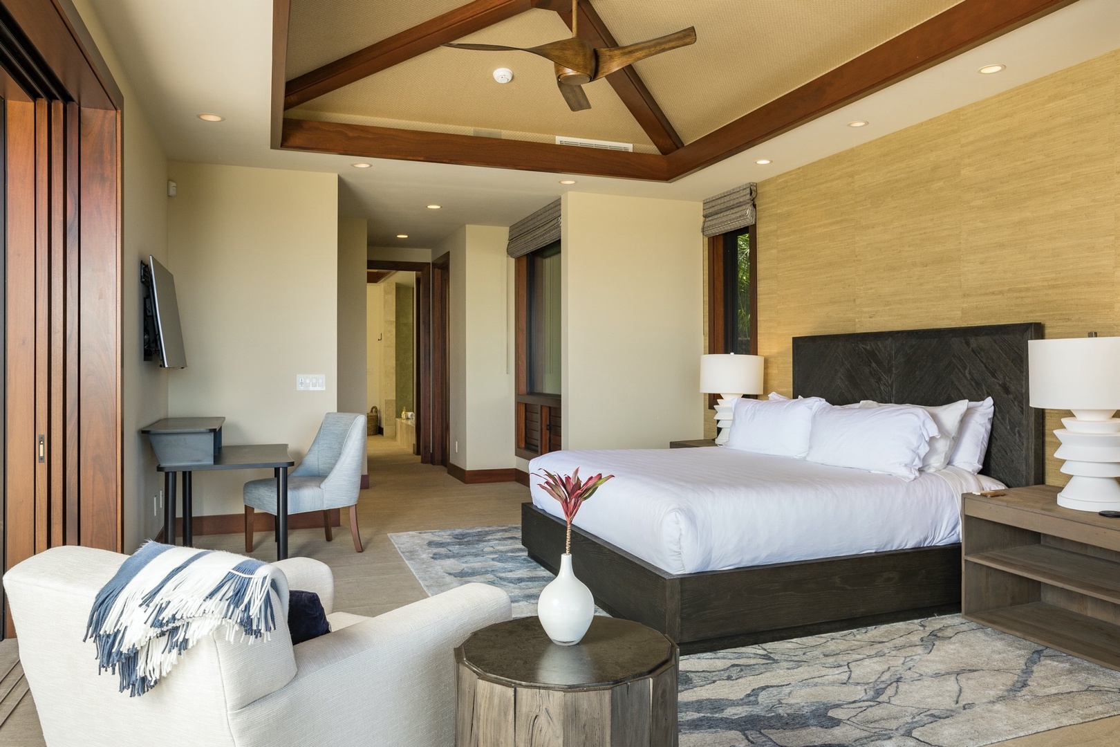 Kailua Kona Vacation Rentals, 4BD Kulanakauhale Estate (3558) at Hualalai Resort - Reverse view of primary suite featuring California King bed, vaulted ceilings, wall-mounted flat screen TV, and desk.