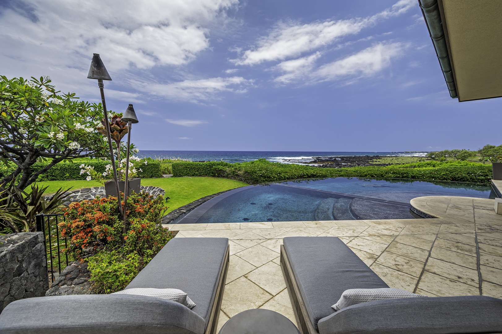 Kailua Kona Vacation Rentals, Alohi Kai Estate** - concrete table and dining chairs all directed toward the Infinity Edge Pool, which is kept at a comfortable 82 degrees and Ocean right behind it