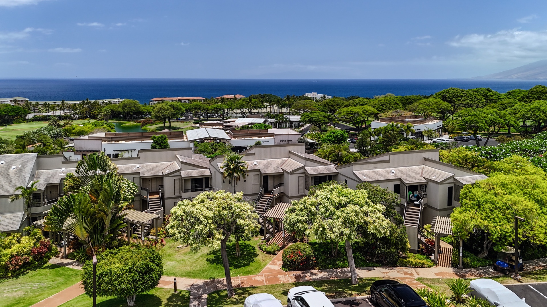 Kihei Vacation Rentals, Wailea Ekolu 204 - The building sits wrapped in flowering trees, close enough to the shops to walk over and just as close to that same stretch of blue.