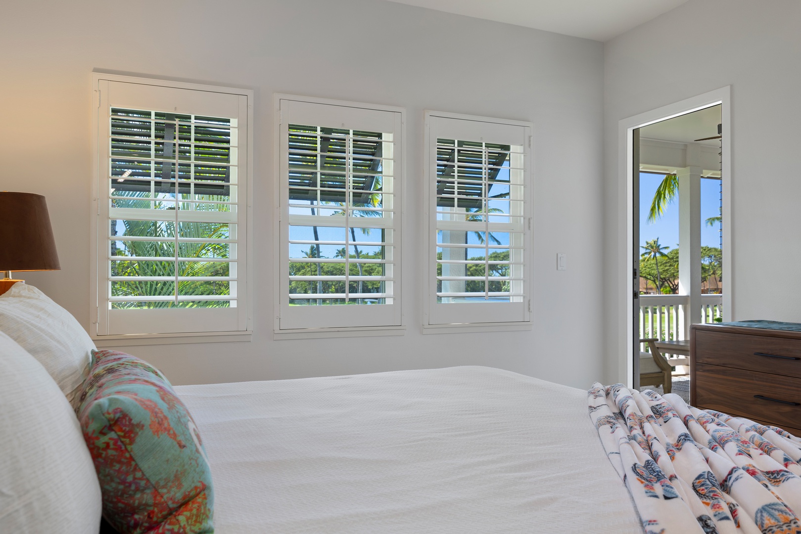 Wake up to tropical paradise views through elegant plantation shutters, with palm trees swaying just beyond your private lanai.