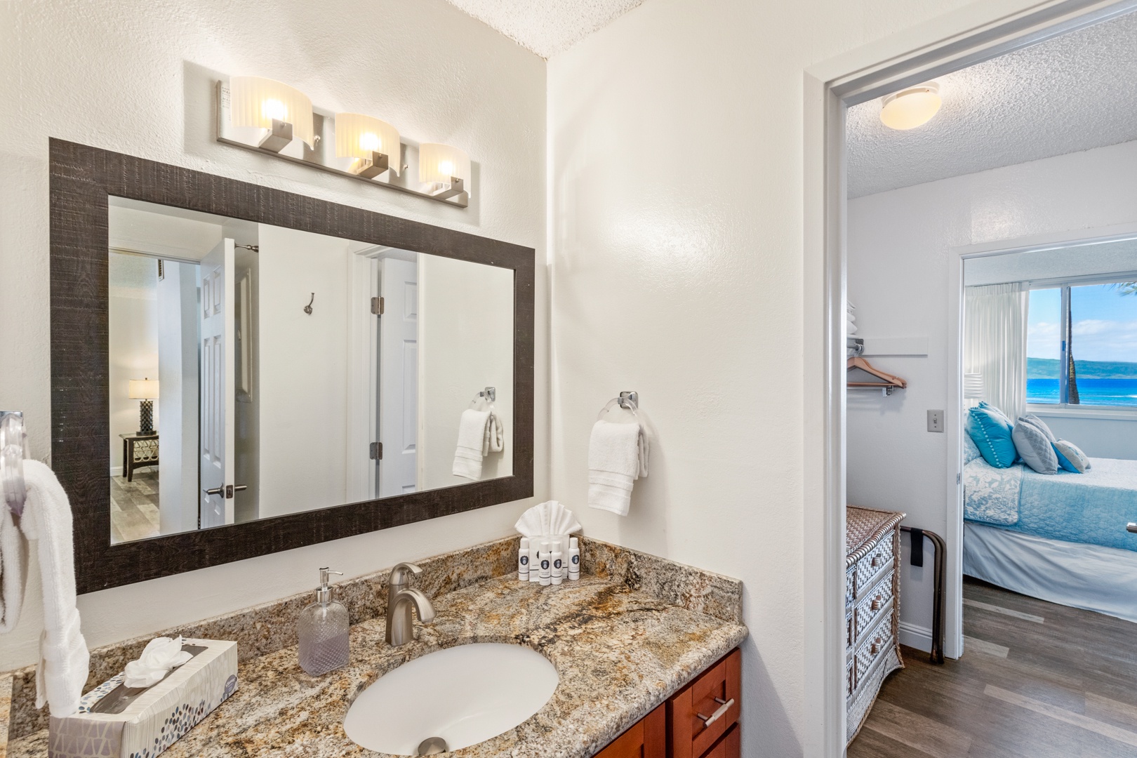 Lahaina Vacation Rentals, Royal Kahana 308 - This bathroom showcases a sleek granite countertop and a modern mirror with warm lighting, offering a functional yet stylish space.