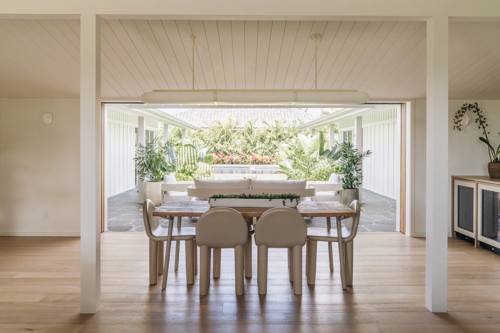 Honolulu Vacation Rentals, Surfside Bungalow** - Large doors open to the courtyard, creating a seamless connection between indoor dining and outdoor living.