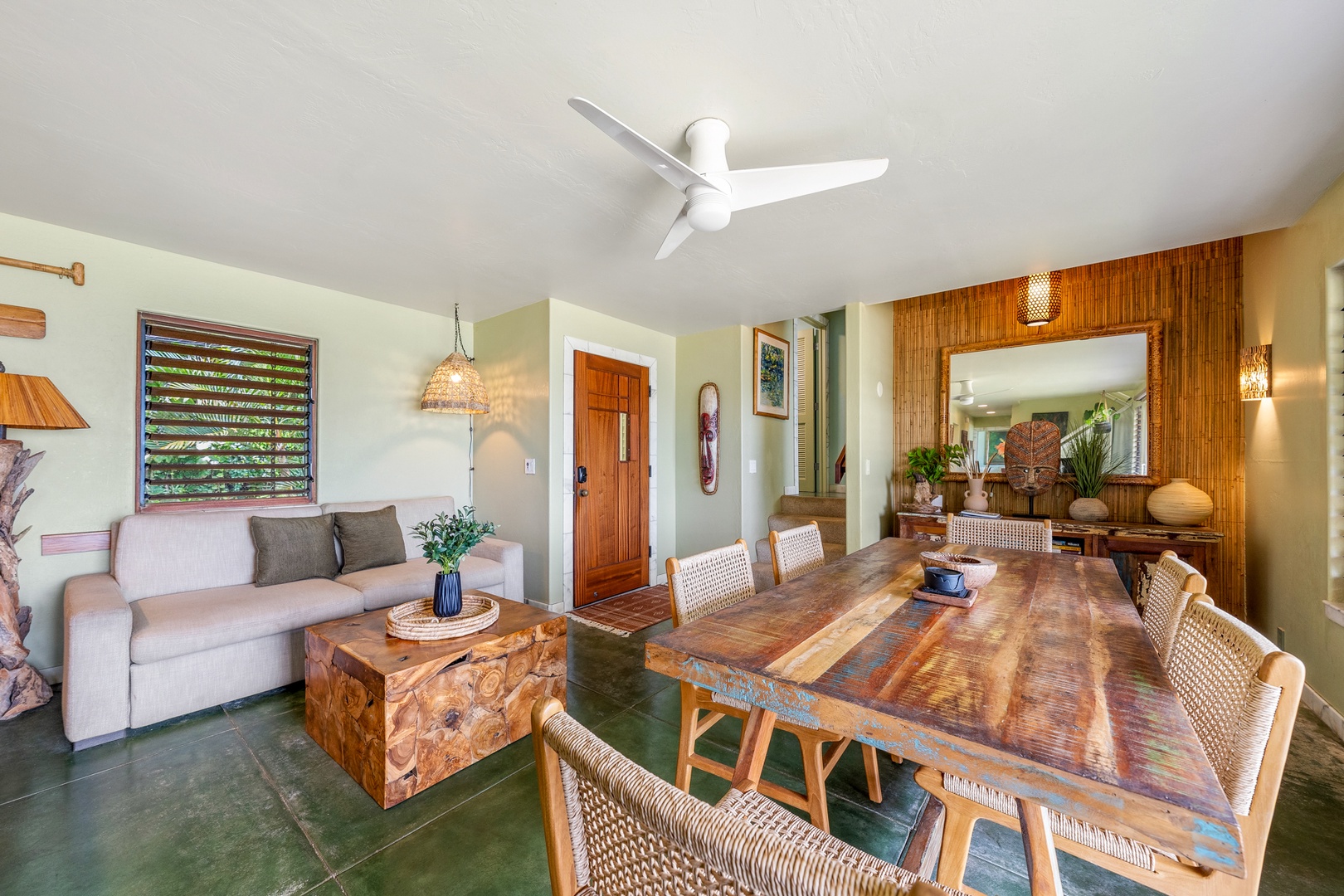 Hanalei Vacation Rentals, Hale Kepuhi - Unwind in your tropical living space featuring natural wood tones, comfortable seating, and a cooling ceiling fan overhead.